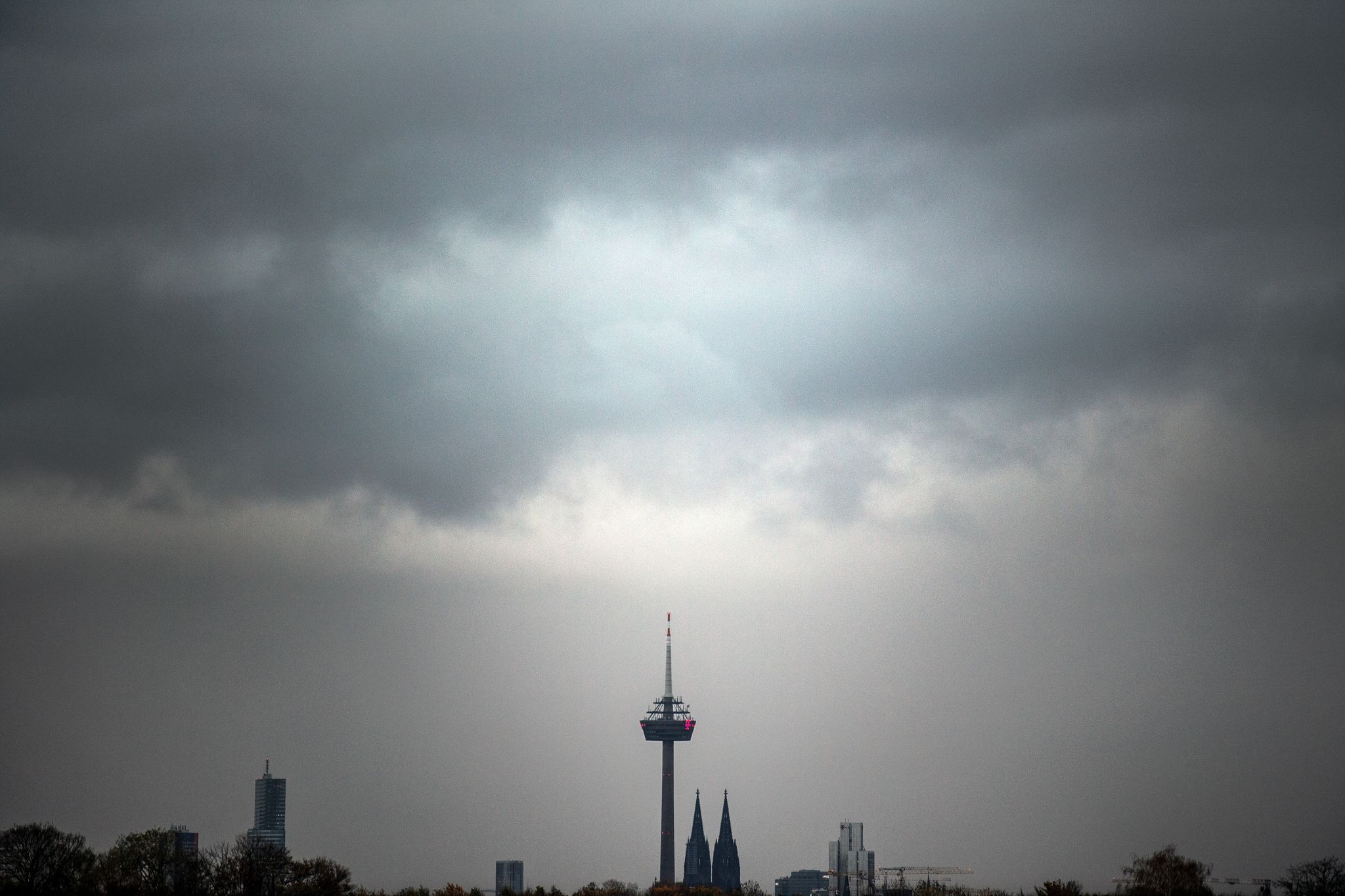 Graue Wolken ziehen über den Kölner Dom und den Fernsehturm