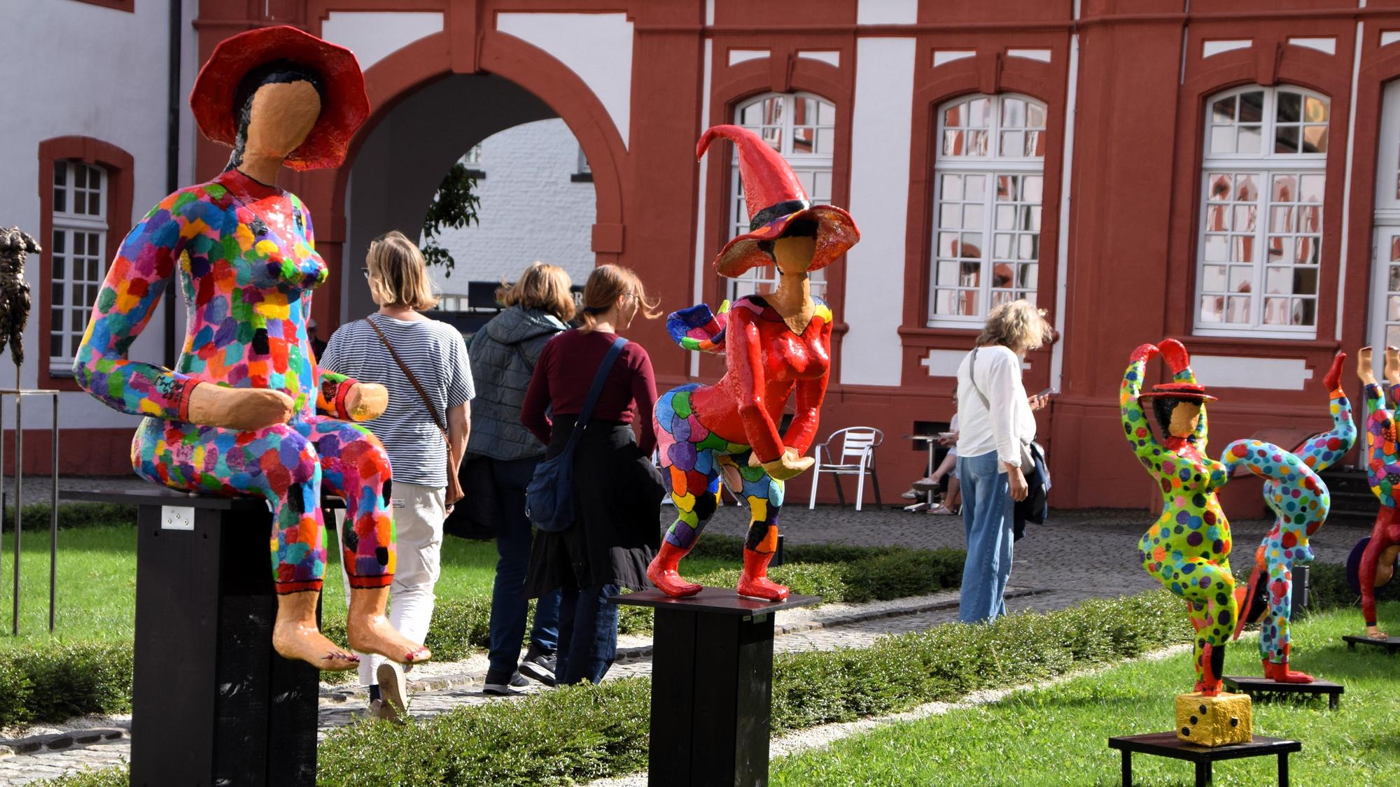 Auf dem Bild sind bunte Skulpturen im Abteihof zu sehen.