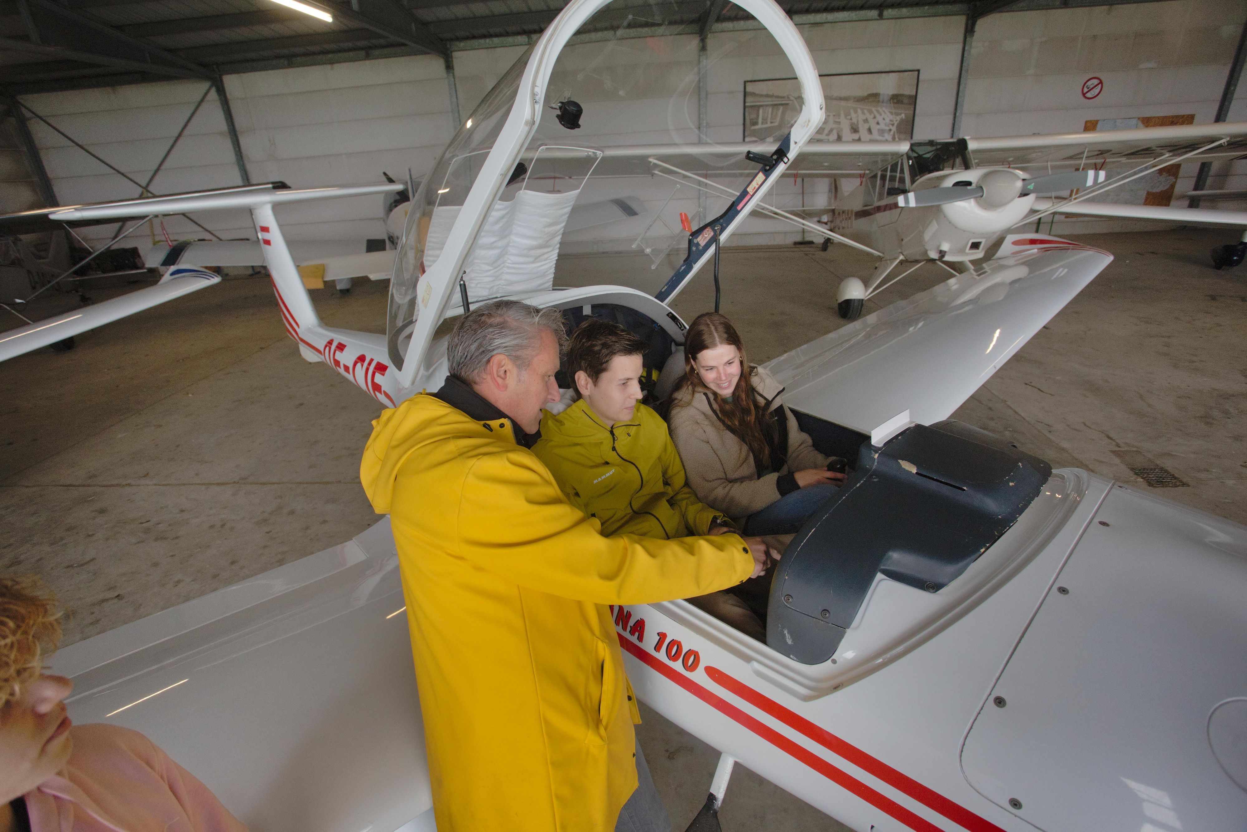 Martin Hisge erklärt Moritz Halking und Helene Iserlohe die Anzeige im Cockpit.