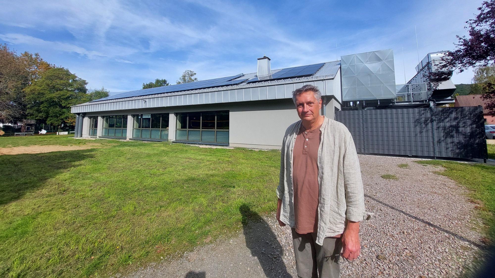 Projektleiter Günther Schuh vor der Hinteransicht mit direktem Übergang in den Dattenfelder Park. Auf dem Dach ist nun eine Fotovoltaikanlage, rechts das neue Technikpodest.