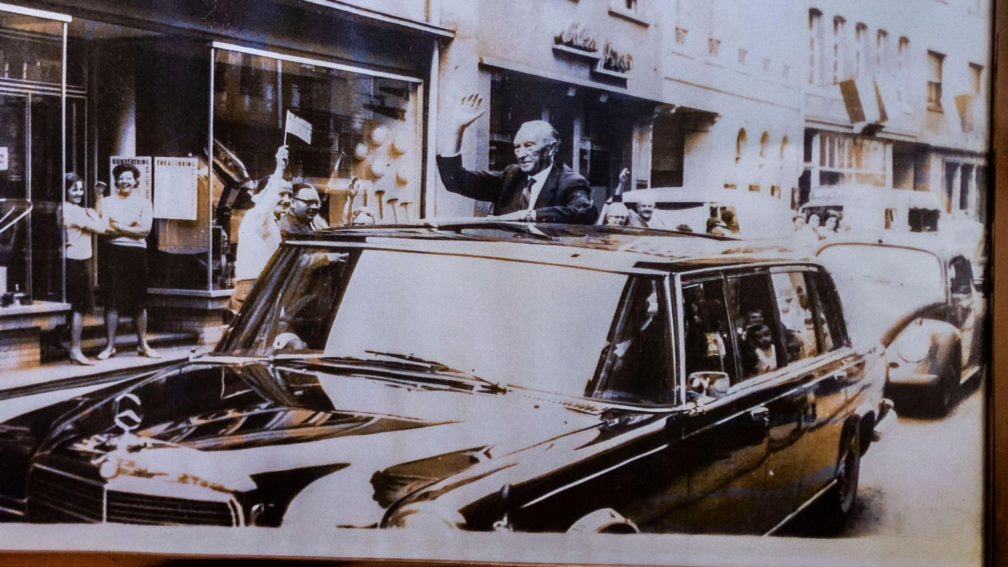Das Bild zeigt den ehemaligen Bundeskanzler, der aus seinem Dienstwagen winkt.