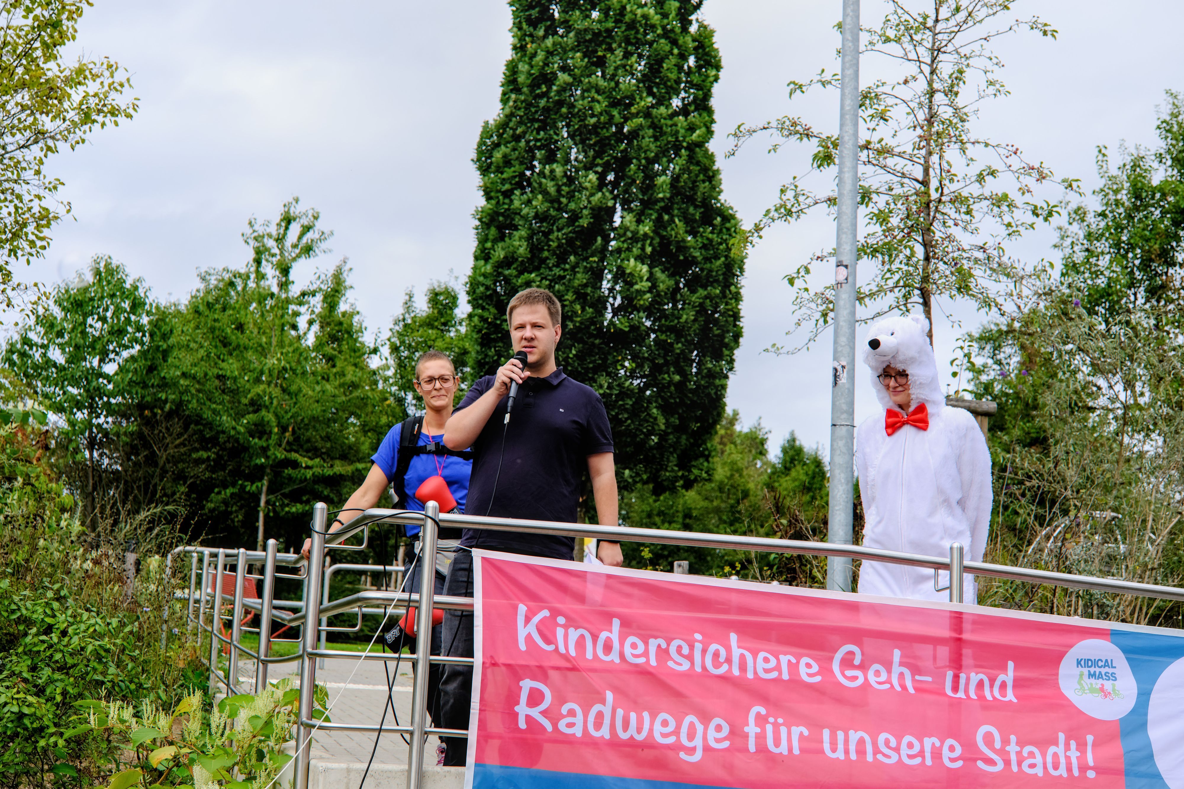 Ein Mann spricht auf einem Wagen in ein Mikrofon.