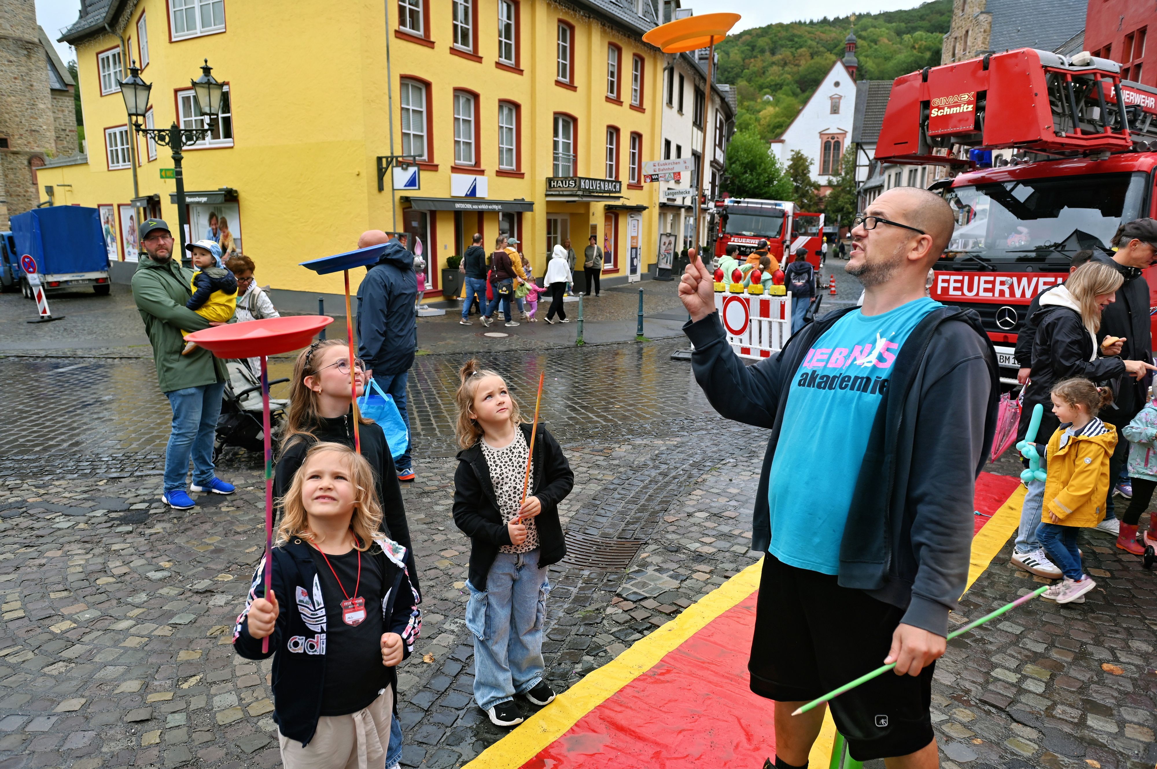 Drei Mädchen  und ein Mann jonglieren mit Tellern.