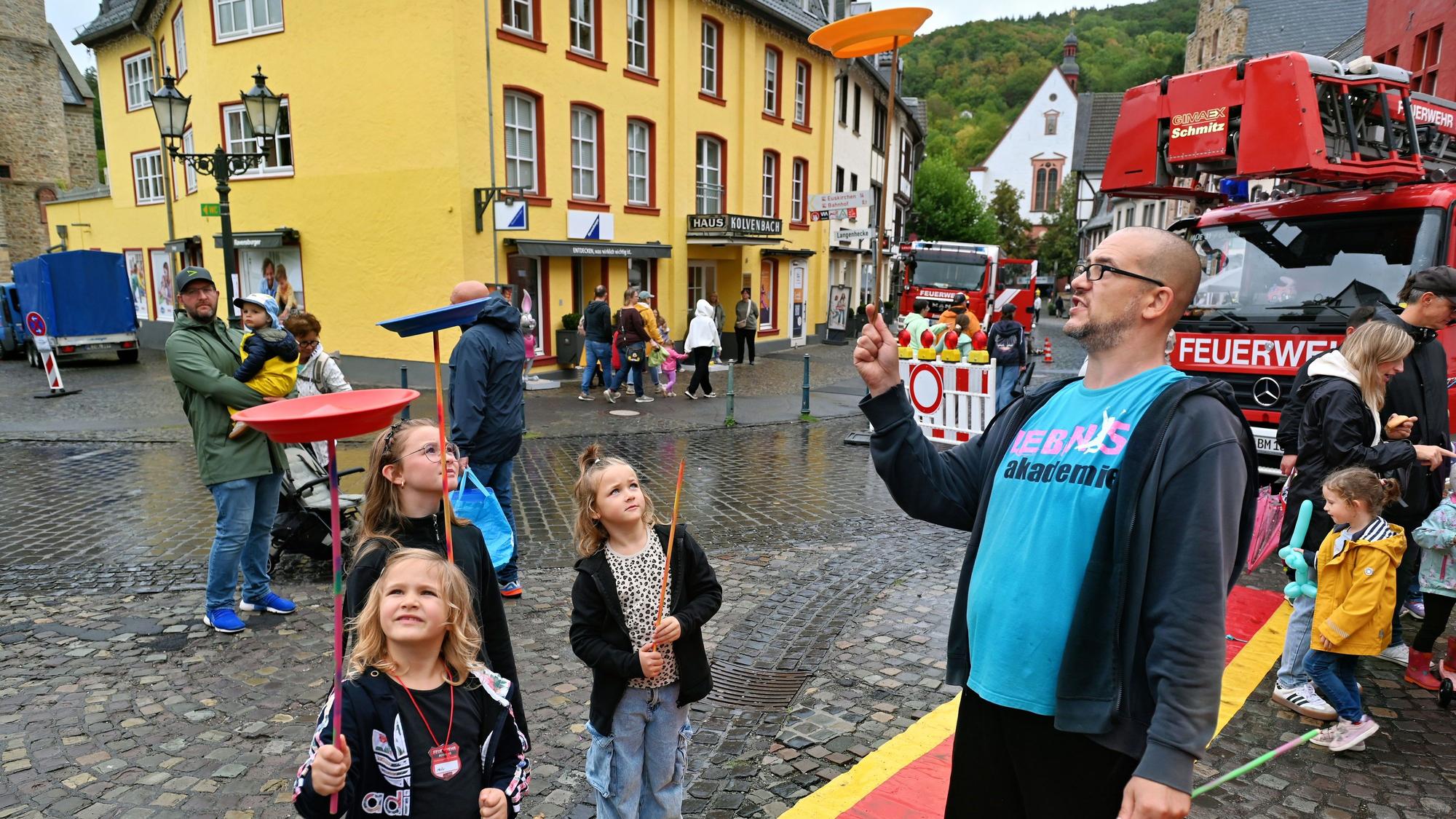 Drei Mädchen und ein Mann jonglieren mit Tellern.