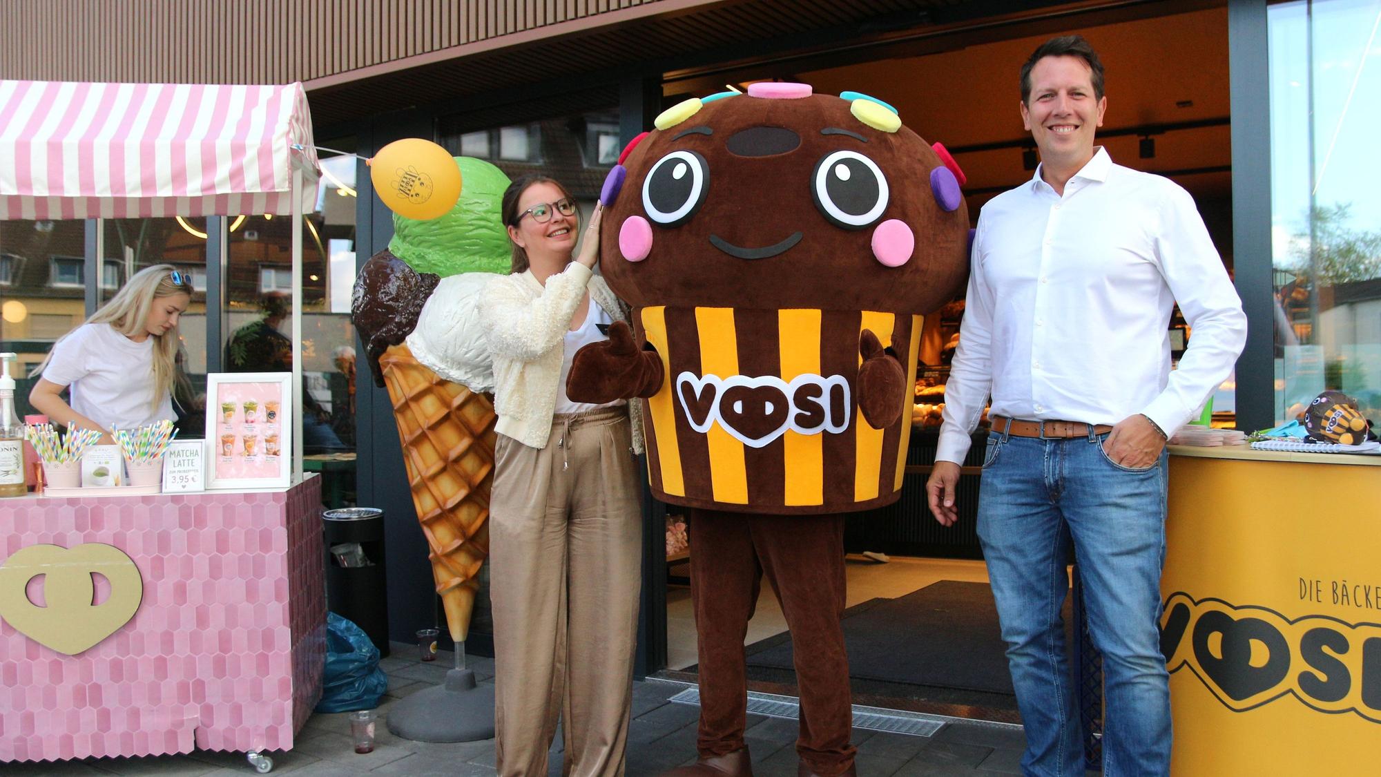 Auf dem Bild ist das Inhaber-Ehepaar der Bäckerei mi einem Maskottchen zu sehen.