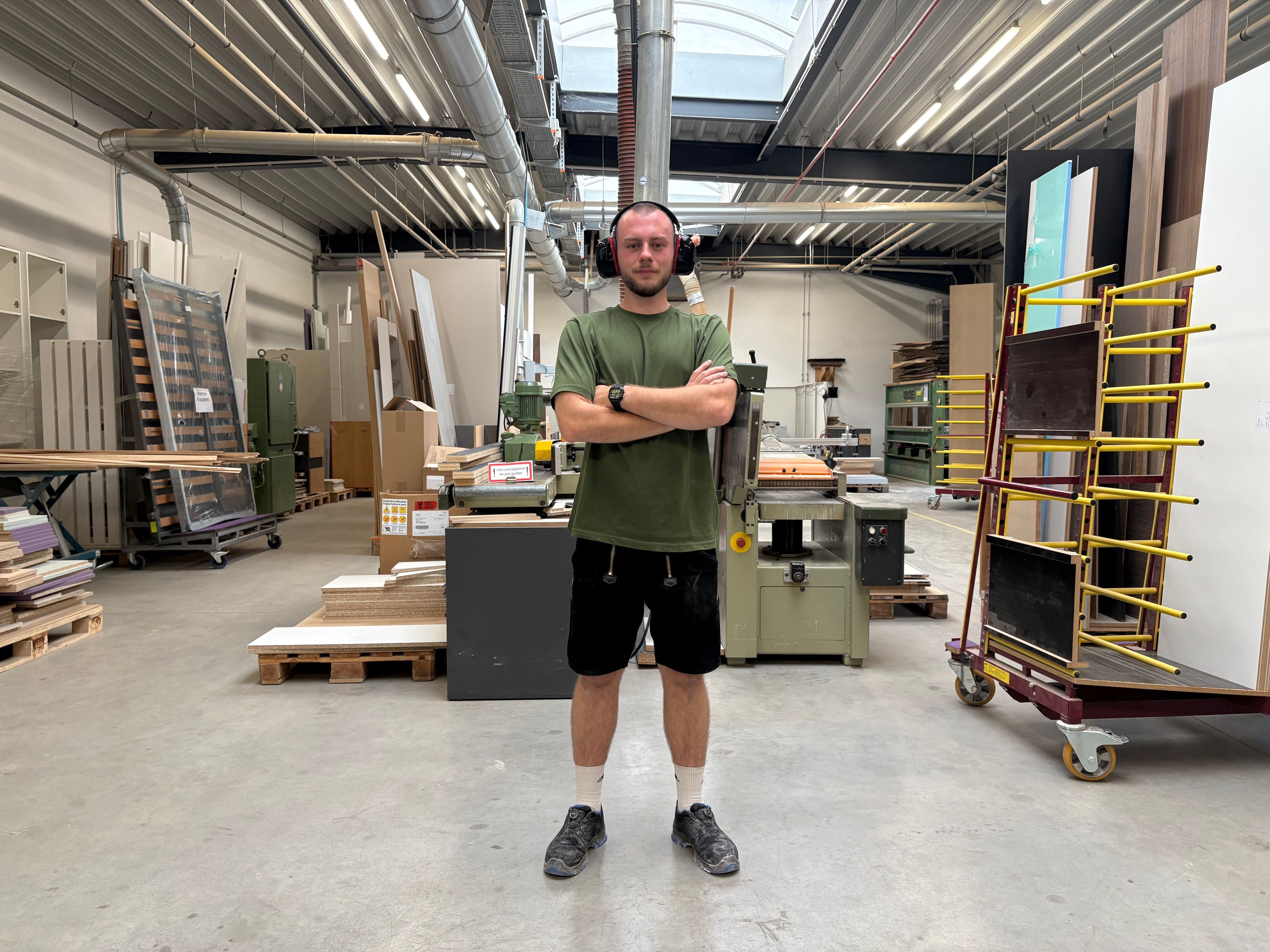 Louis posiert mit Hörschutz in der Werkstatt.