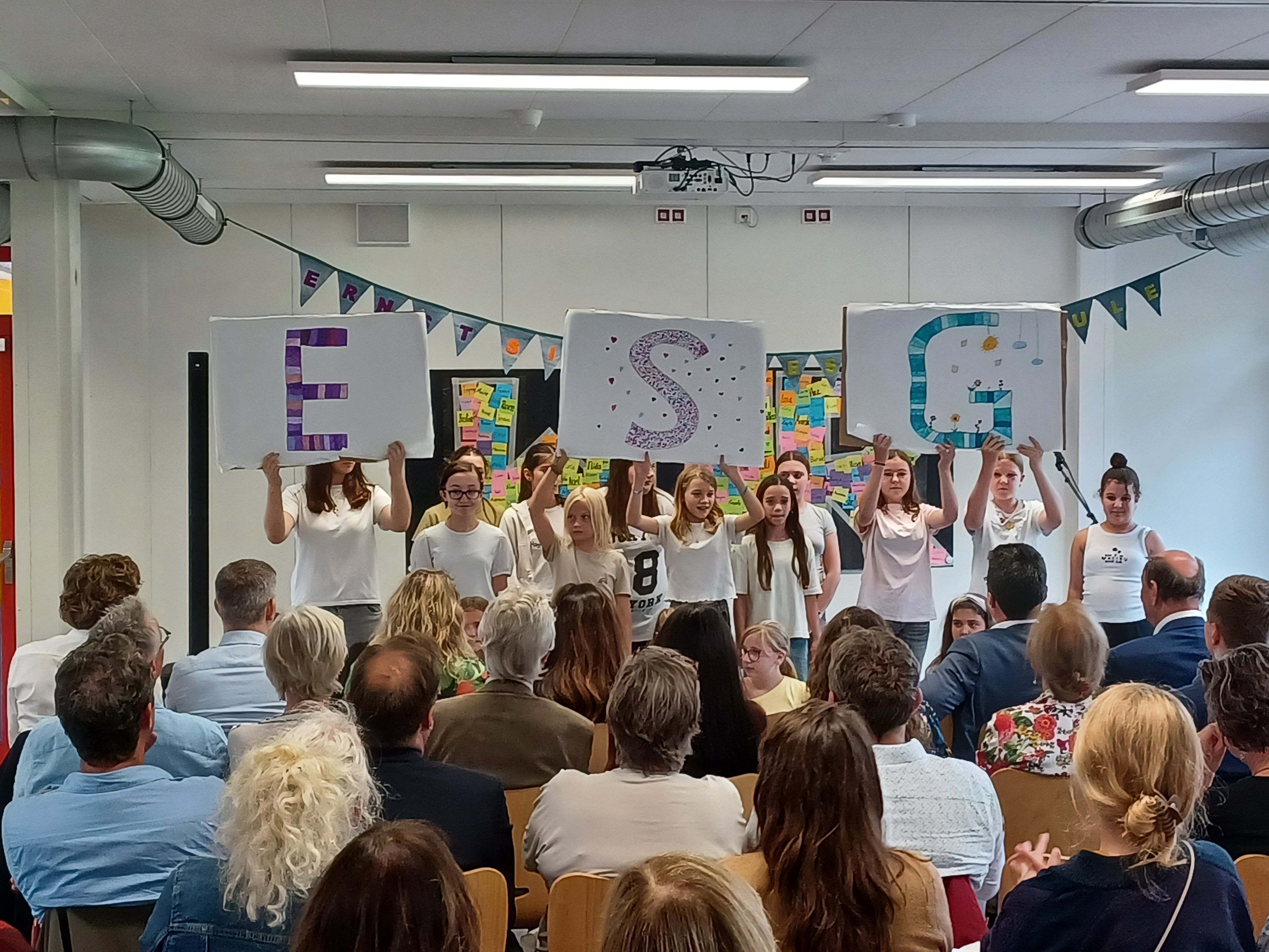 Schüler stehen vor ihrem Publikum in einer Klasse.
