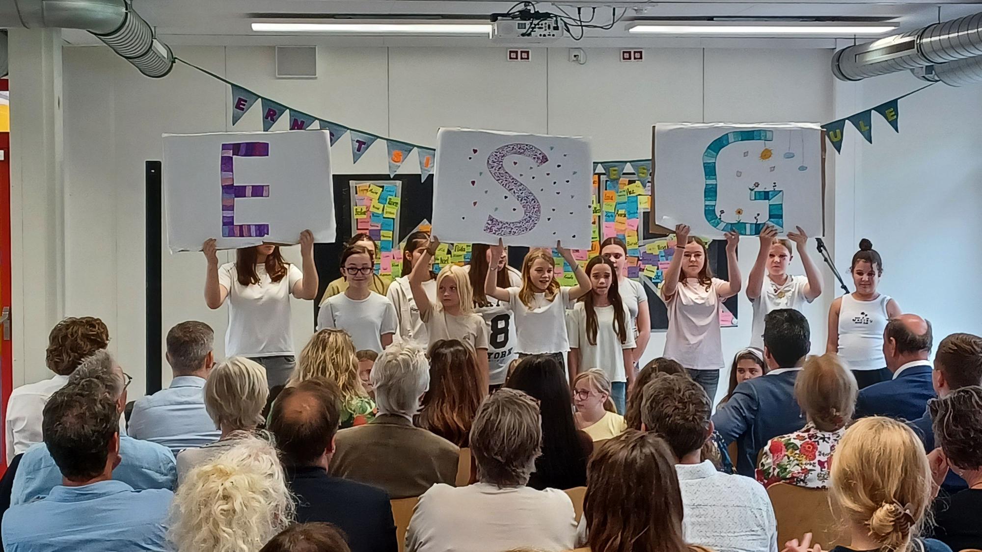 Schüler stehen vor ihrem Publikum in einer Klasse.