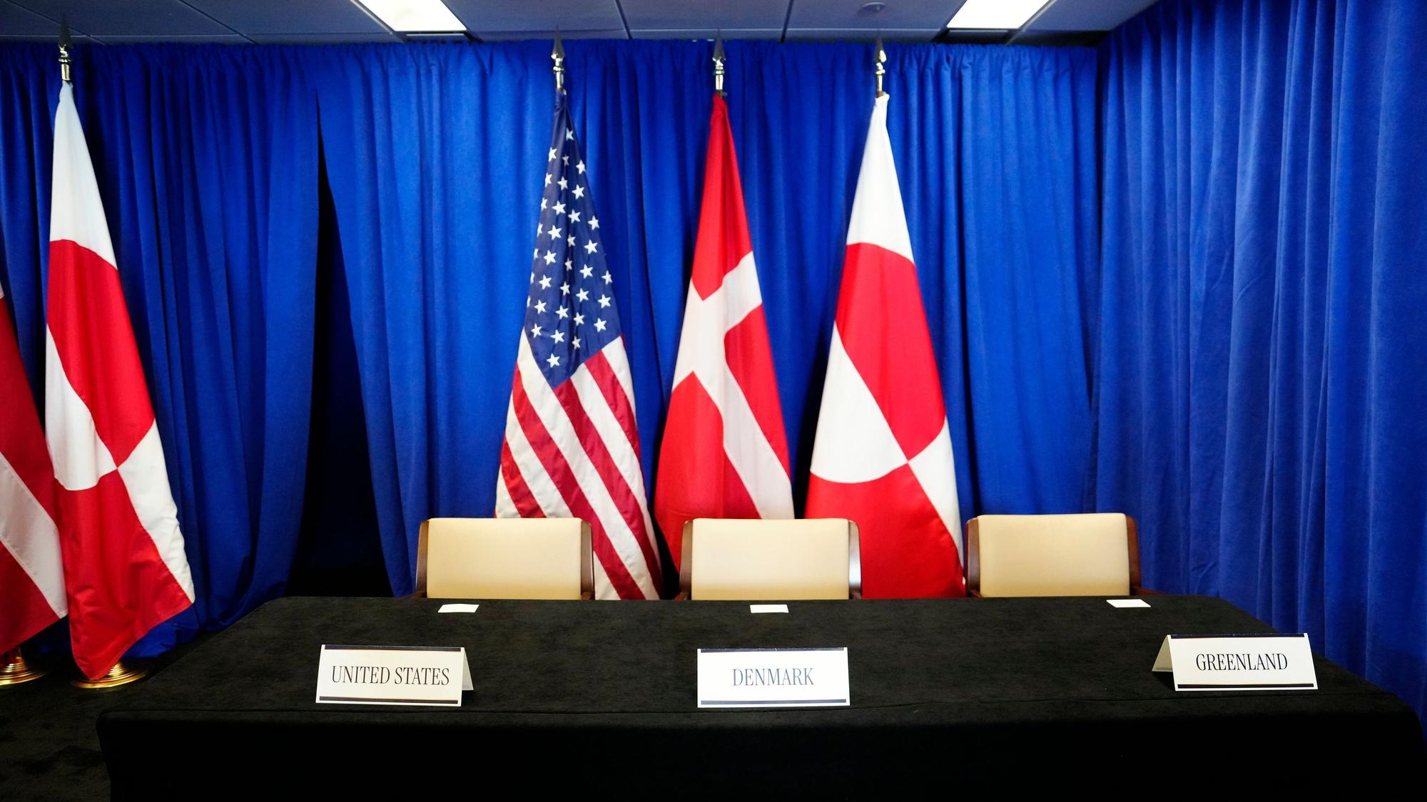 Die Flaggen der USA (M, l-r), Dänemarks und Grönlands stehen in einem Raum anlässlich der Unterzeichnungszeremonie eines Sicherheitsabkommens zwischen den USA, Dänemark und Grönland im Hauptquartier der Vereinten Nationen.