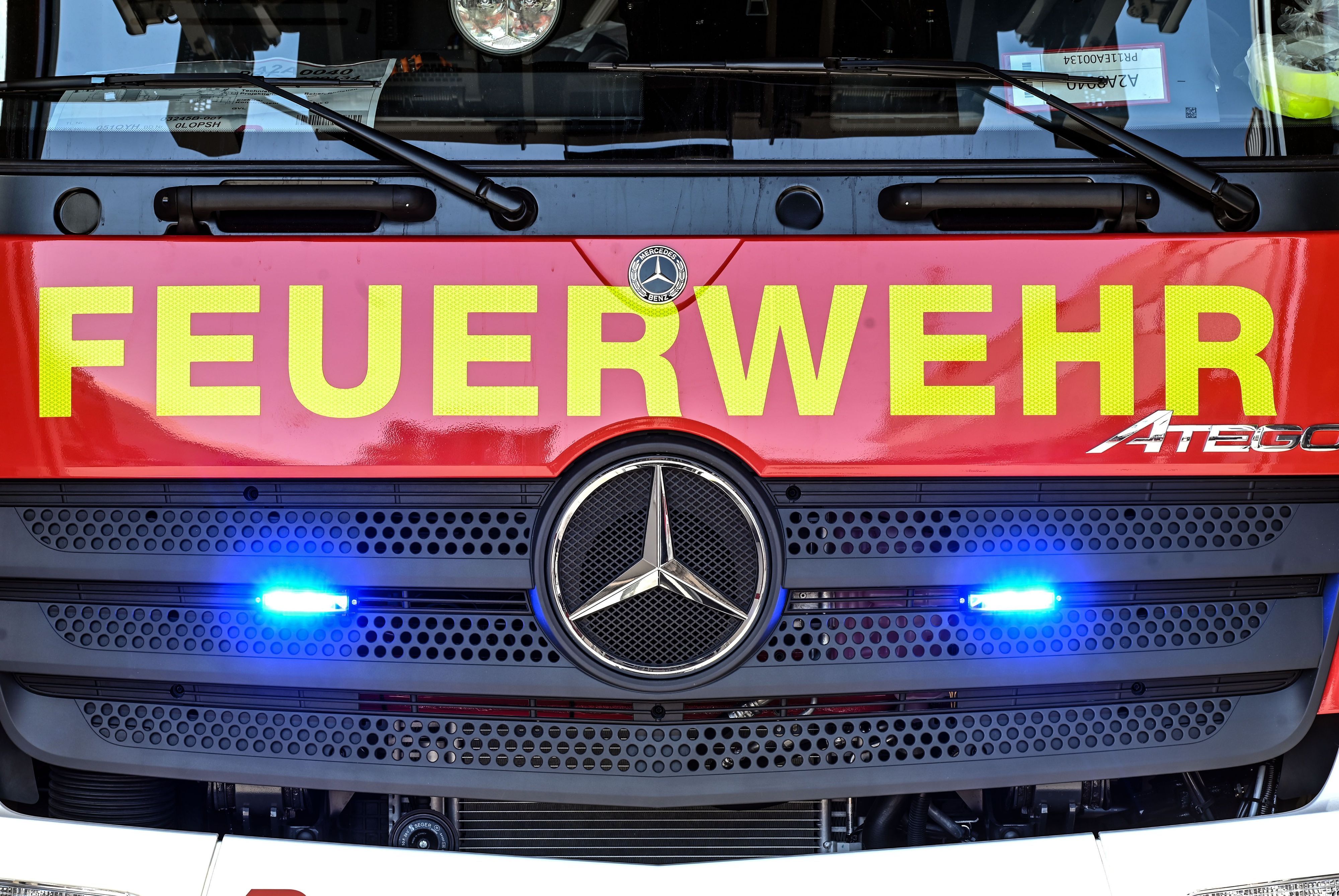 An einem Feuerwehrfahrzeug leuchten unter dem Schriftzug „Feuerwehr“ zwei Blaulichter.