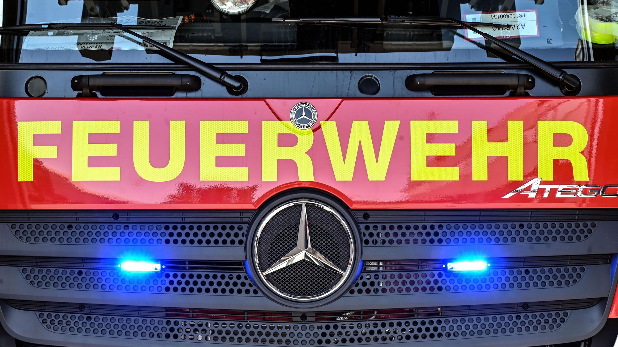 An einem Feuerwehrfahrzeug leuchten unter dem Schriftzug „Feuerwehr“ zwei Blaulichter.