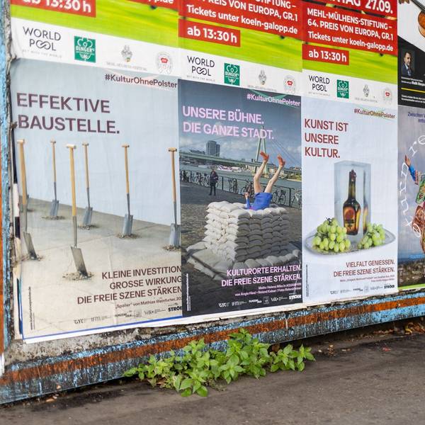 Plakate unter einer Brücke.