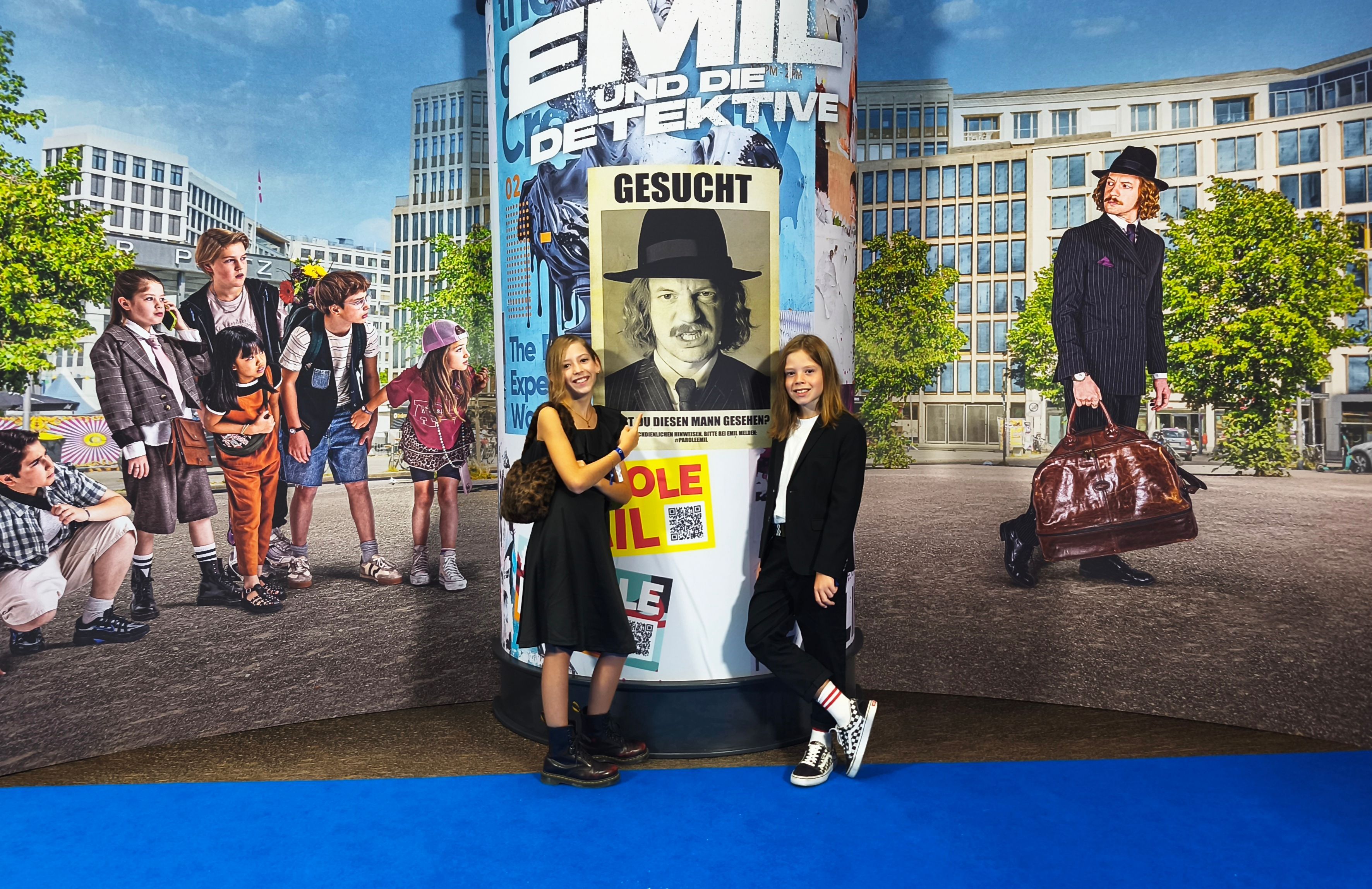 Bei der Filmpremiere in Berlin posieren Bela (r.) und seine Schwester Charlotte auf dem blauen Teppich vor einer riesigen Fotowand.
