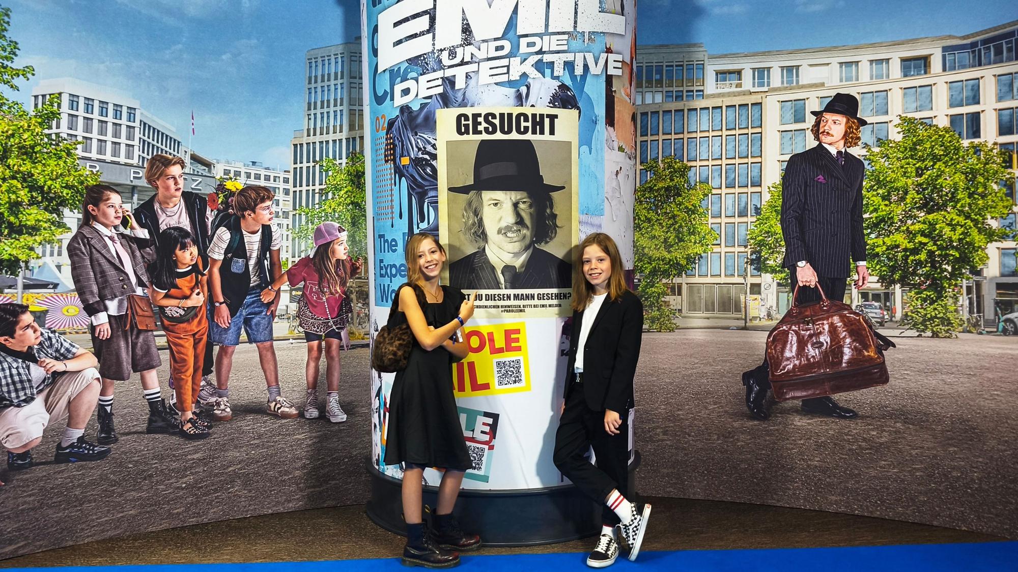 Bei der Filmpremiere in Berlin posieren Bela (r.) und seine Schwester Charlotte auf dem blauen Teppich vor einer riesigen Fotowand.