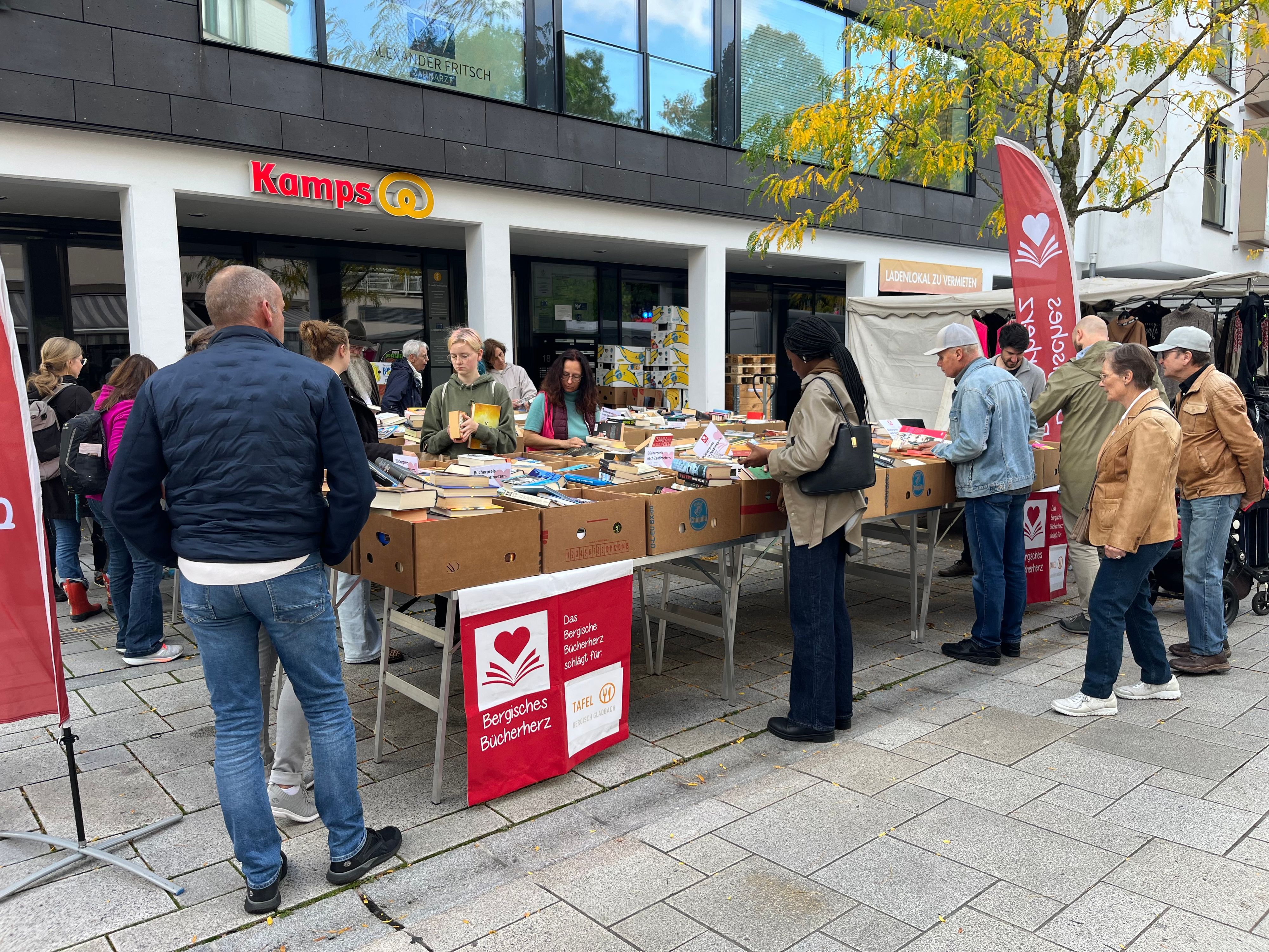 ein Stand mit Bananenkisten, darin Bücher. Menschen stehen am Stand