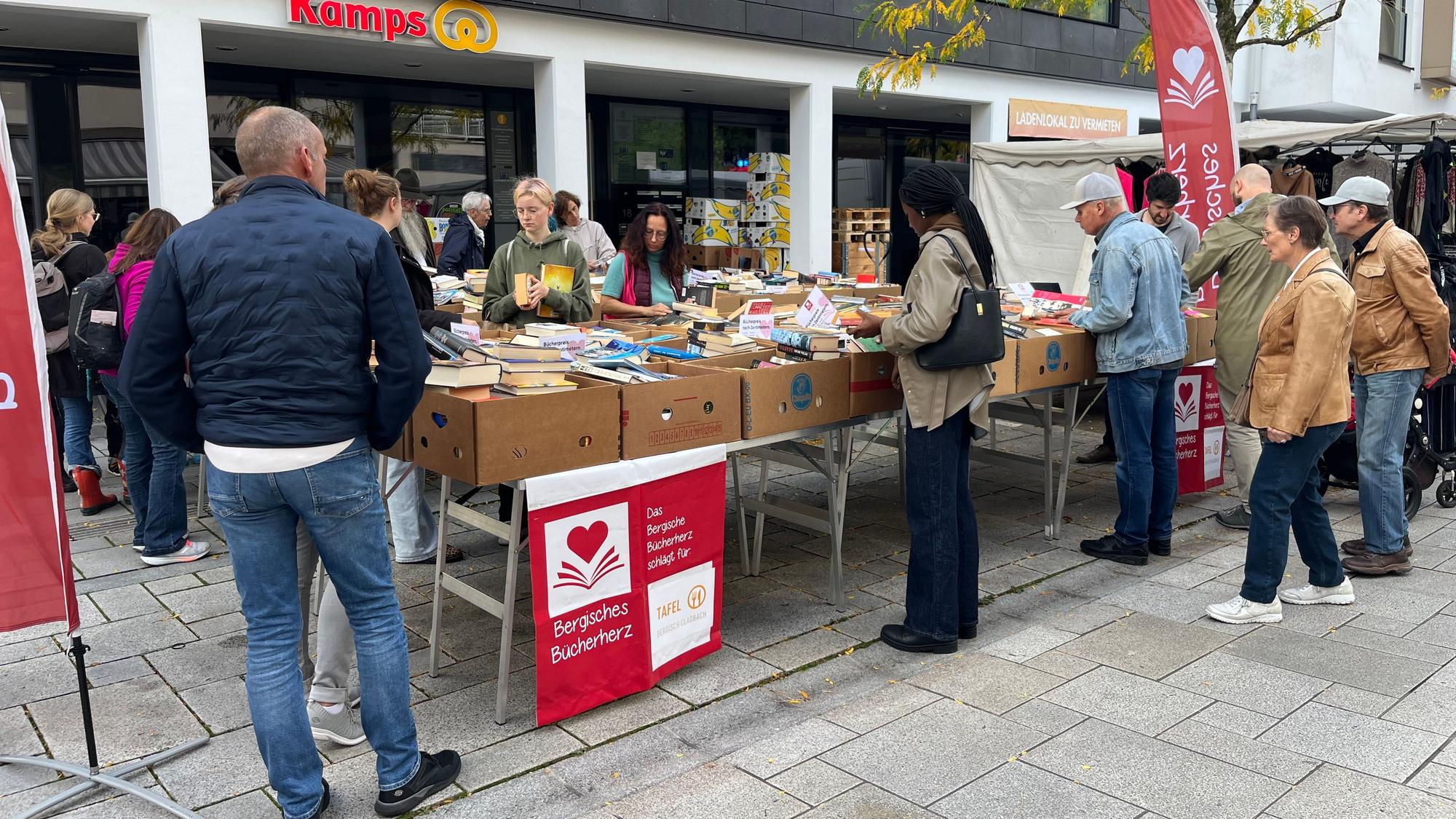 ein Stand mit Bananenkisten, darin Bücher. Menschen stehen am Stand