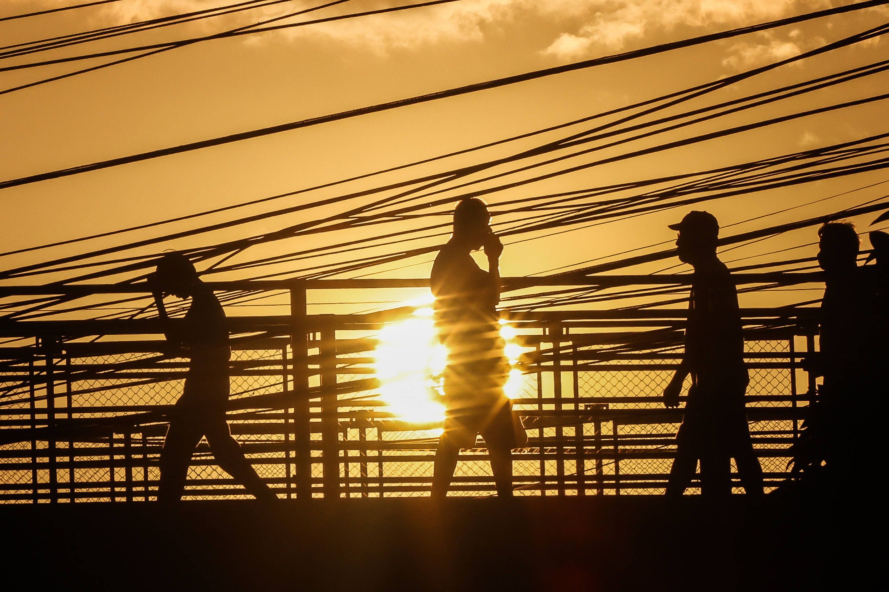Menschen gehen unter der sengenden Sonne in Quezon City auf den Philippinen spazieren. (Archivbild)