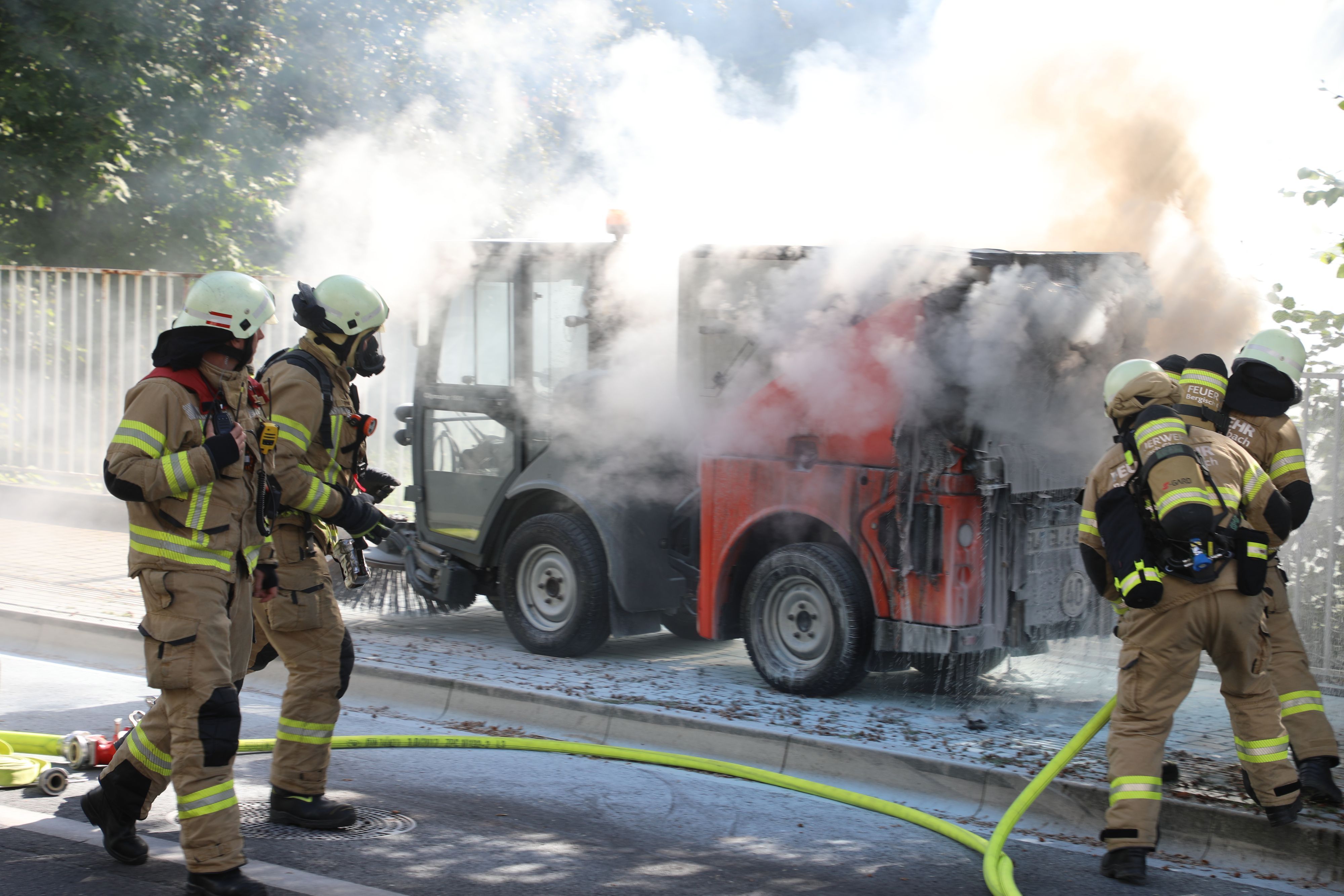 Einsatzkräfte der Feuerwehr löschen die brennende Kehrmaschine an der Gohrsmühle.