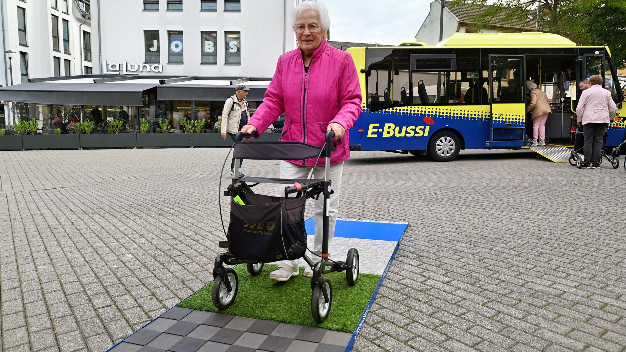 Eine Frau schiebt einen Rollator über verschiedene Beläge.