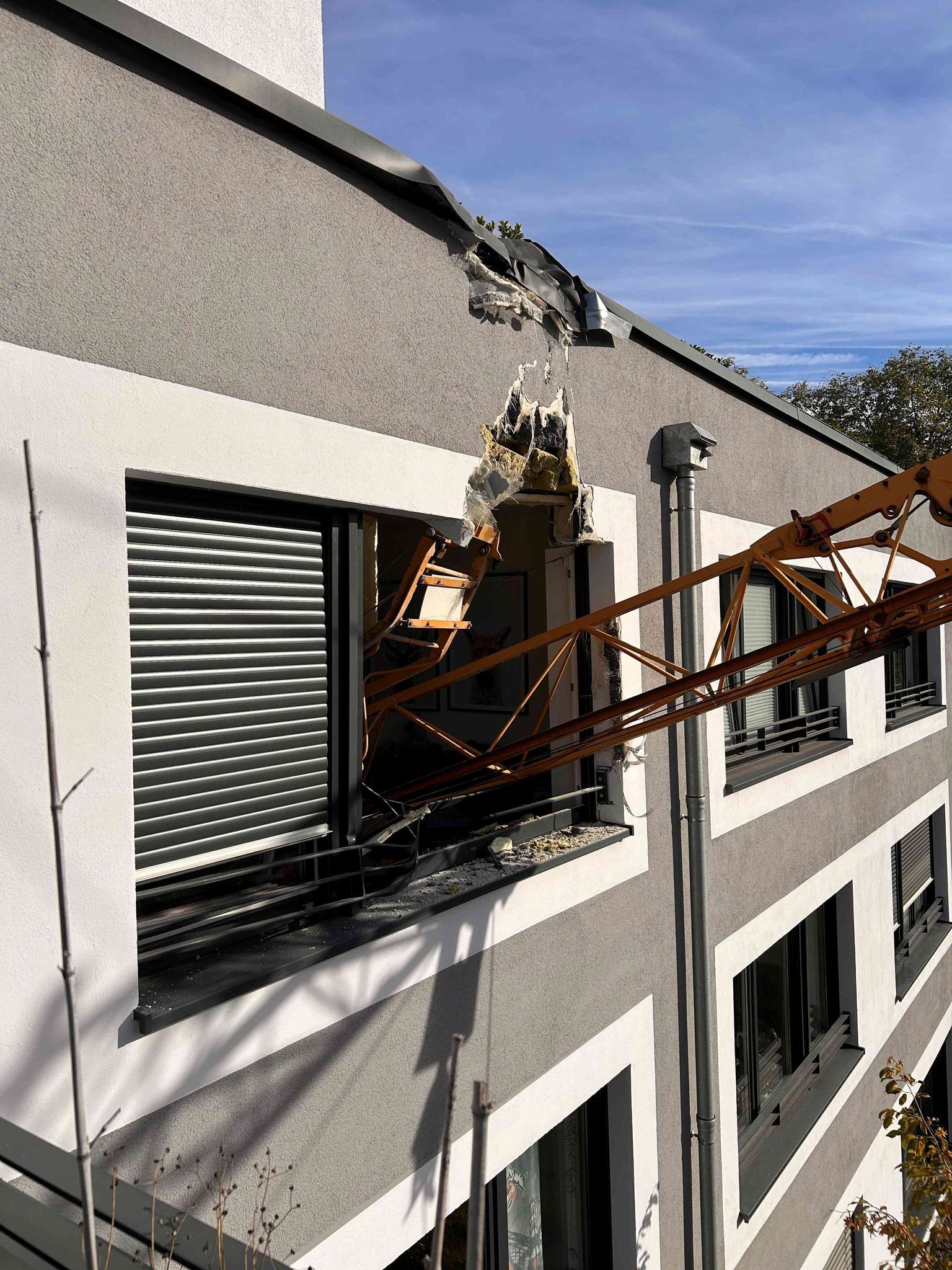 Kran kippt und stürzt auf Wohnhaus