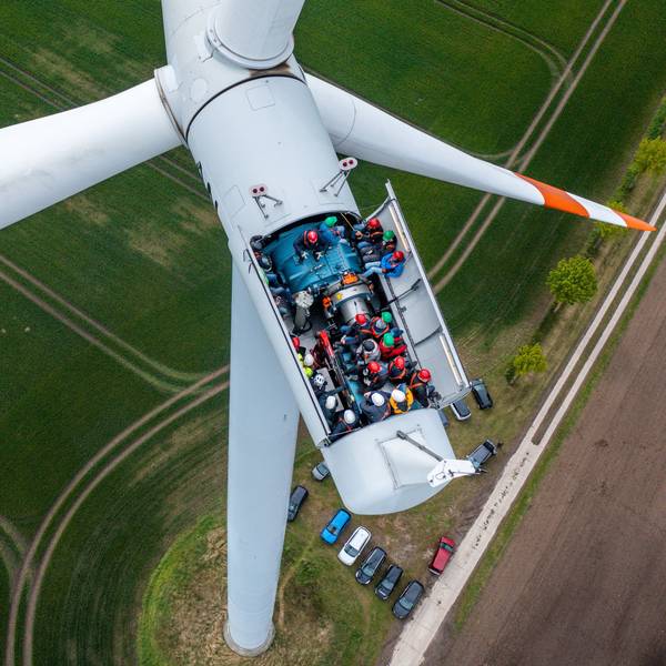 Bürgermeister, Lokalpolitiker und interessierte Bürger besichtigten die Turbinen auf einer Windkraftanlage mit geöffnetem Dach.