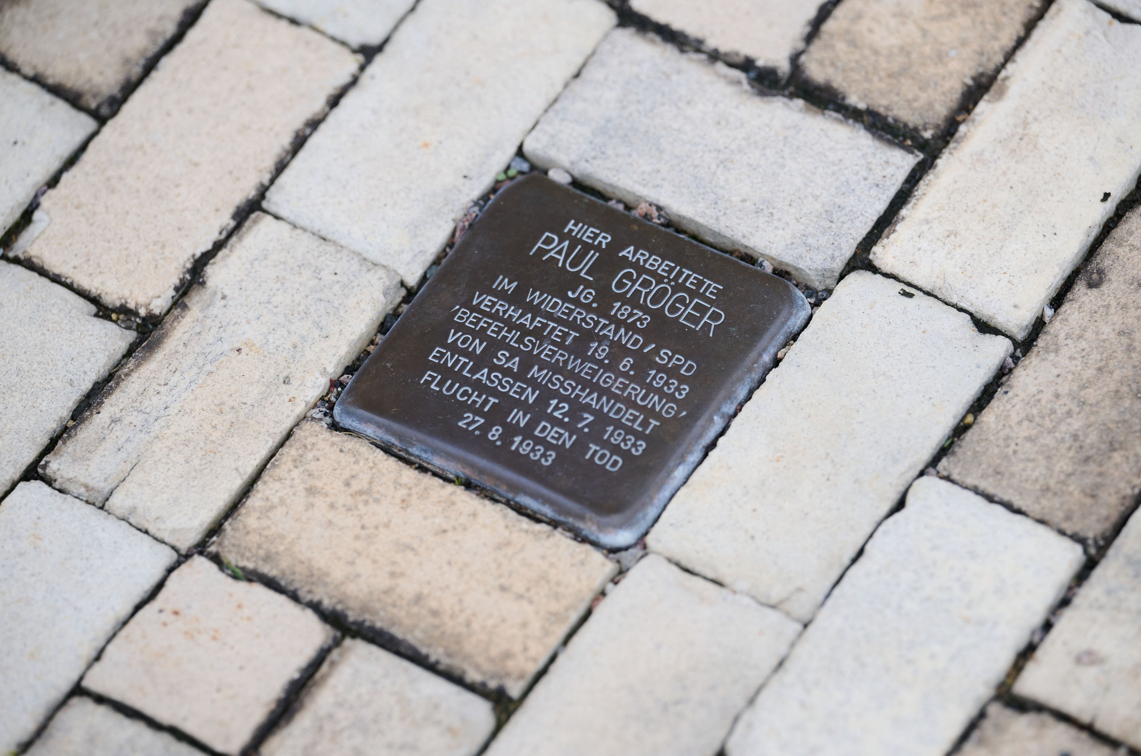 Ein Stolperstein, zur Erinnerung an NS-Opfer Paul Gröger, ist vor dem Rathaus in den Fußweg eingelassen. Der Stadtrat von Heidenau bei Dresden lässt keine neuen Stolpersteine im Straßenraum mehr zu.
