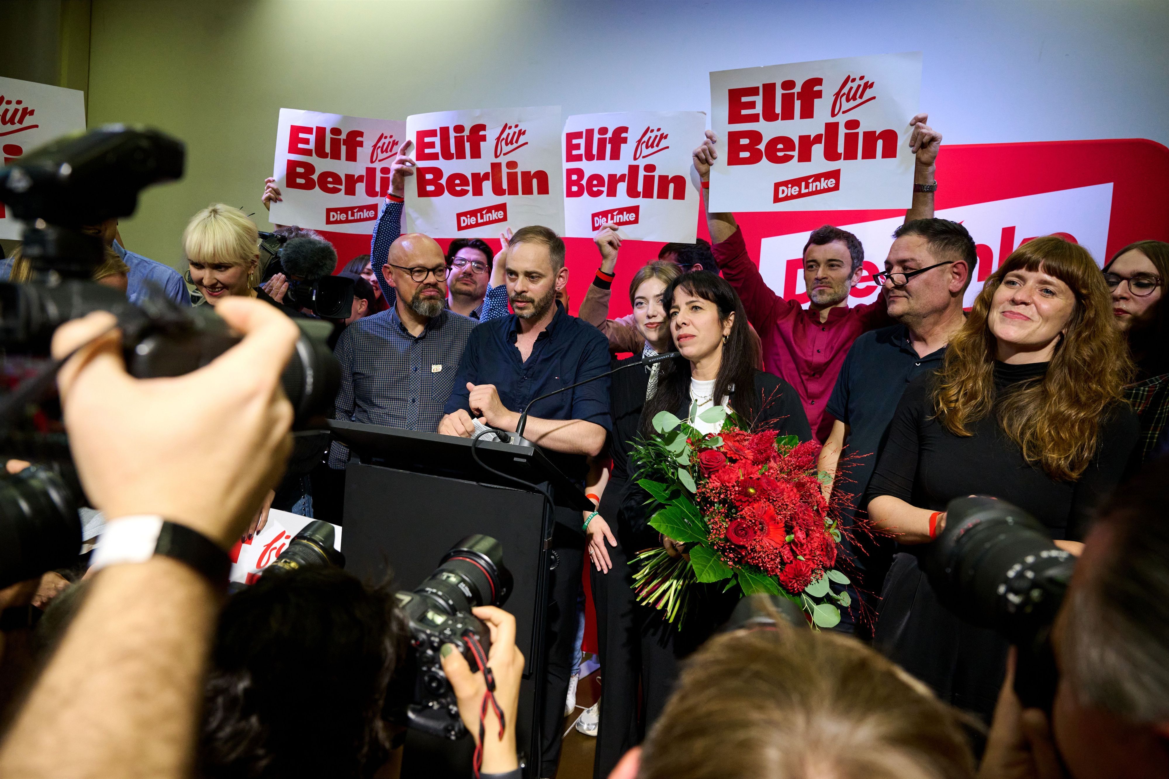 Elif Eralp steht mit einem Blumenstrauß auf dem Podium.