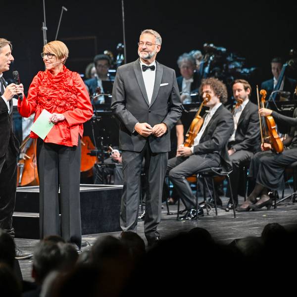 Kay Voges, Bettina Böttinger und Hein Mulders stehen auf einer Bühne.