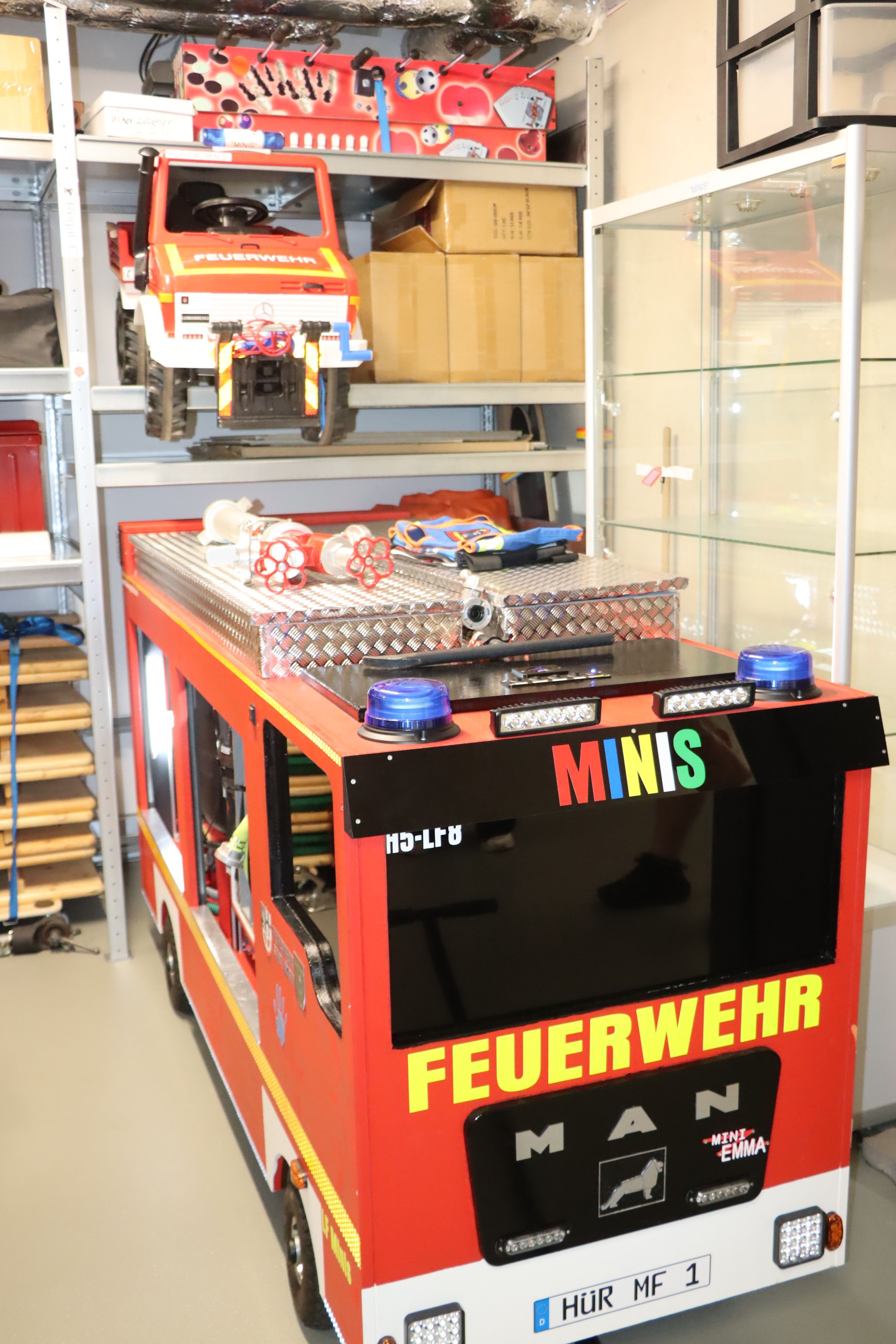 Auf dem Bild ist ein selbst gebautes Feuerwehrauto für Kinder zu sehen.