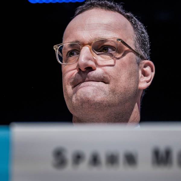 Jens Spahn sitzt im Bundestag und zieht die Lippen ein.