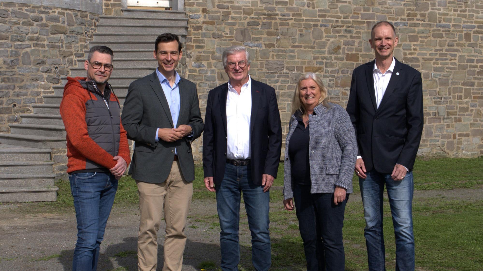 Fünf Menschen stehen vor Schloss Lerbach.
