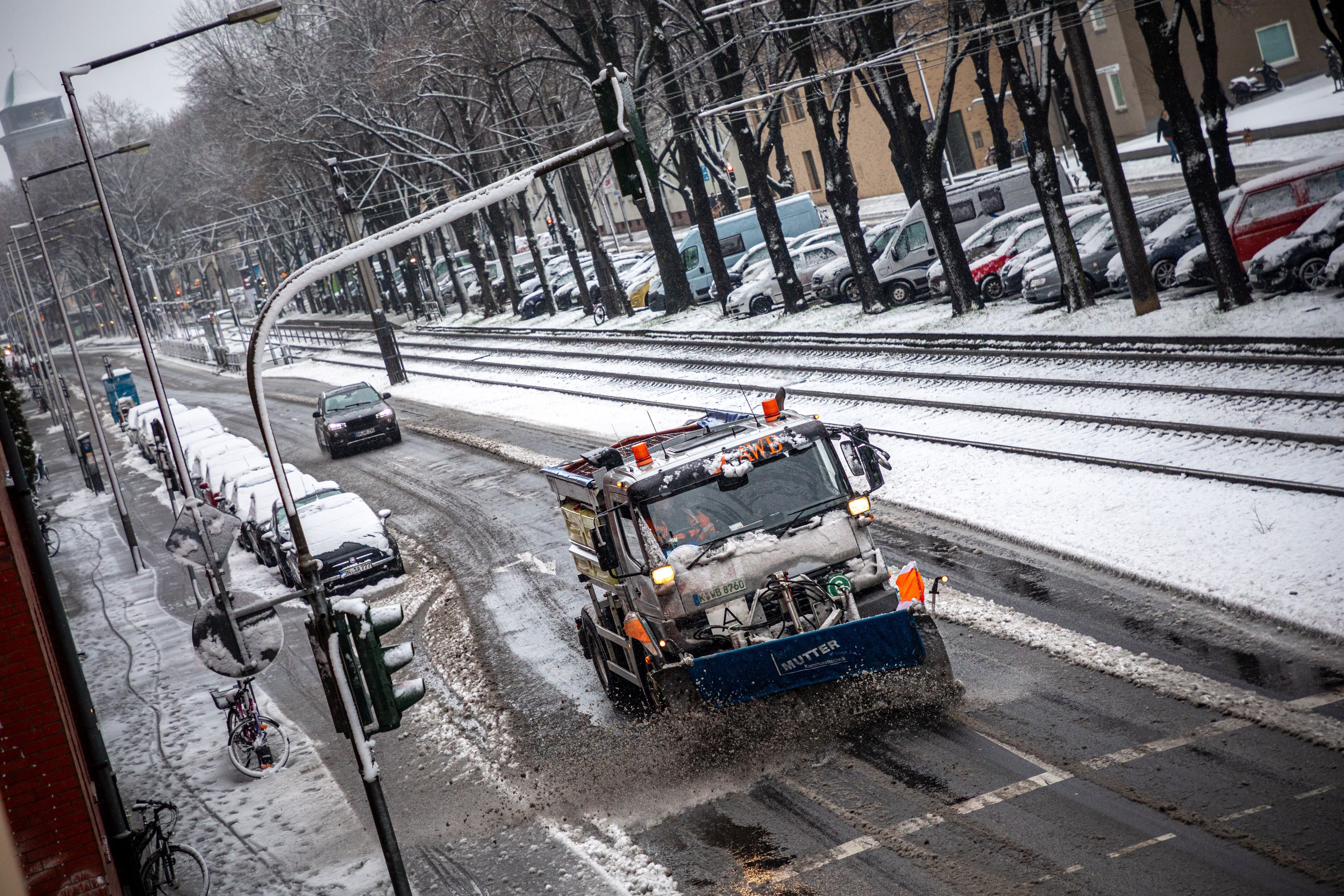 24.01.2021, Köln: Ein mit einem Schneepflug ausgerüstet Fahrzeug der Abfallwirtschaftsbetriebe Köln (AWB) räumt mit seinem Räumschild Schnee und streut Streusalz auf der Straße „Sülzgürtel“. Nach Schneefall liegt in der Stadt eine dünne Schneedecke. Der nasse und schwere Schnee sorgt für matschige Straßen. Foto: Matthias Heinekamp