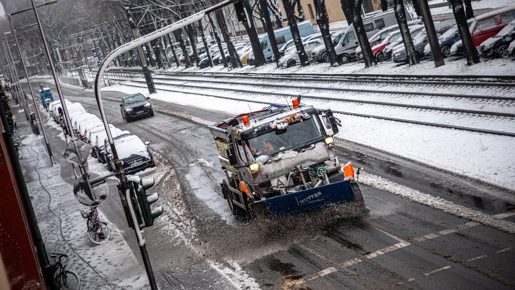 24.01.2021, Köln: Ein mit einem Schneepflug ausgerüstet Fahrzeug der Abfallwirtschaftsbetriebe Köln (AWB) räumt mit seinem Räumschild Schnee und streut Streusalz auf der Straße „Sülzgürtel“. Nach Schneefall liegt in der Stadt eine dünne Schneedecke. Der nasse und schwere Schnee sorgt für matschige Straßen. Foto: Matthias Heinekamp