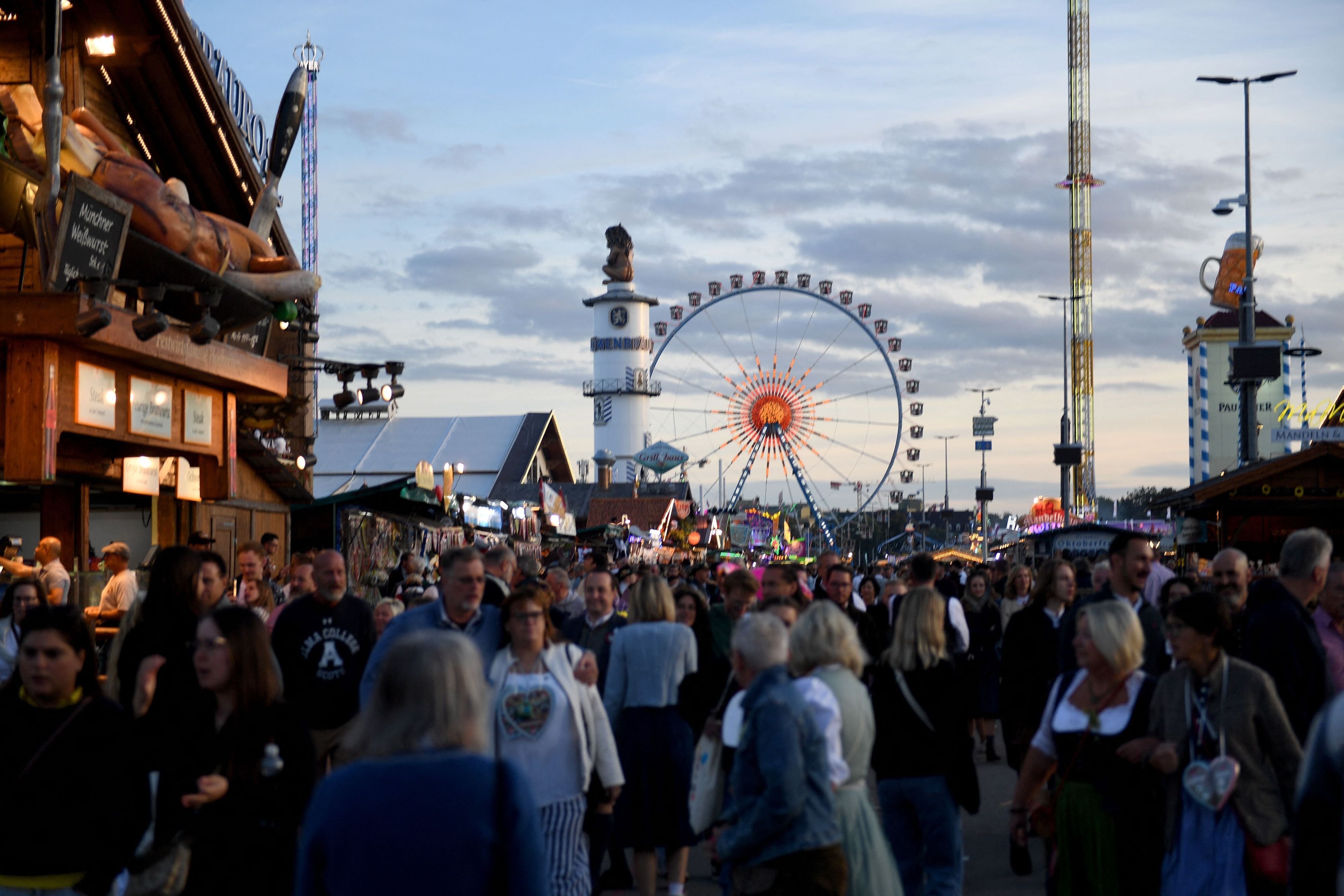 Wiesngäste gehen über das Oktoberfest.