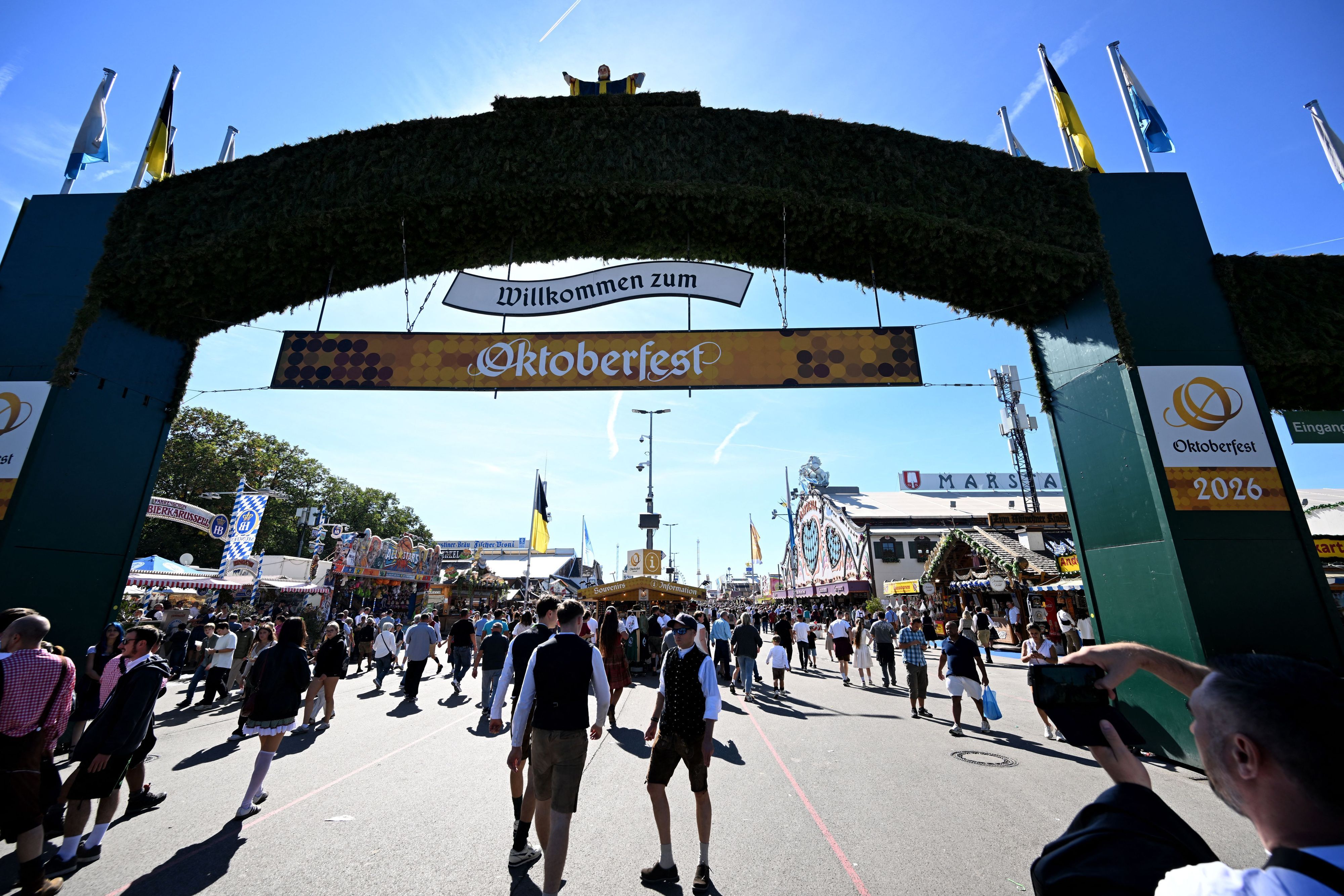 Die Sonne scheint über dem Eingang zum Oktoberfest. Die 191. Wiesn findet vom 19. September bis zum 04. Oktober 2026 auf der Münchner Theresienwiese statt.