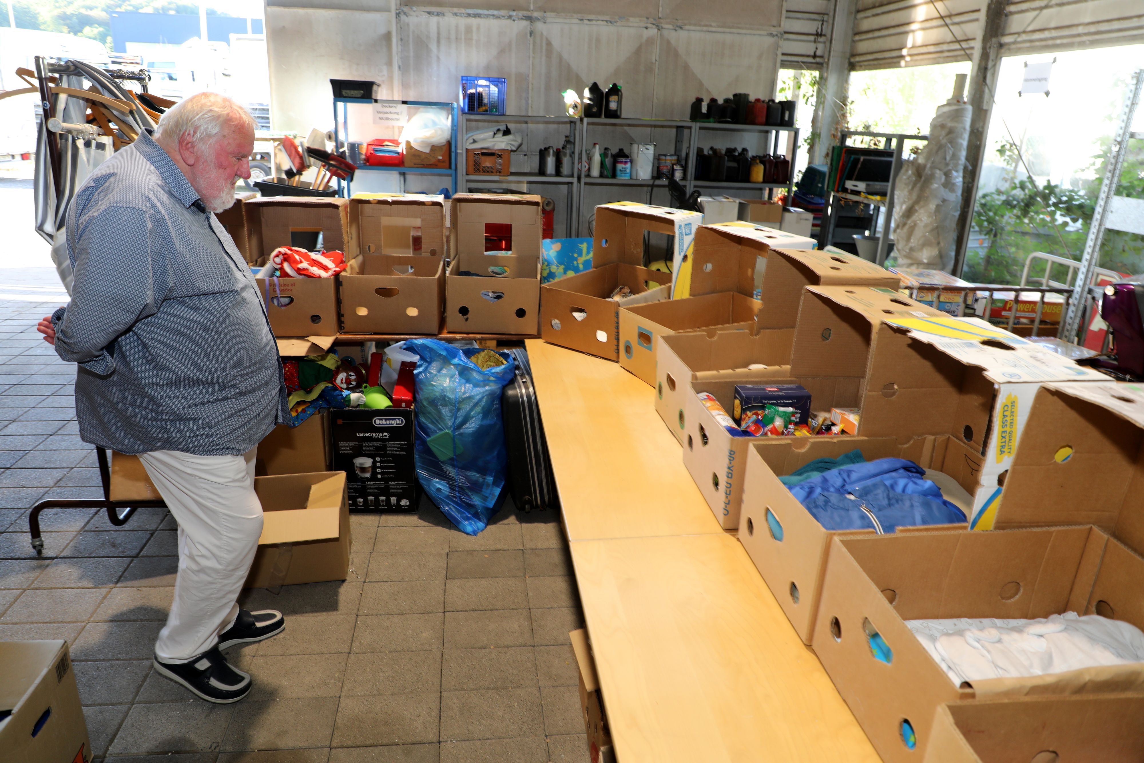 Stifter Erich Bethe schaut auf Kartons in der neuen Sortieranlage im Hilfsgüterlager der Humanitären Hilfe Overath.