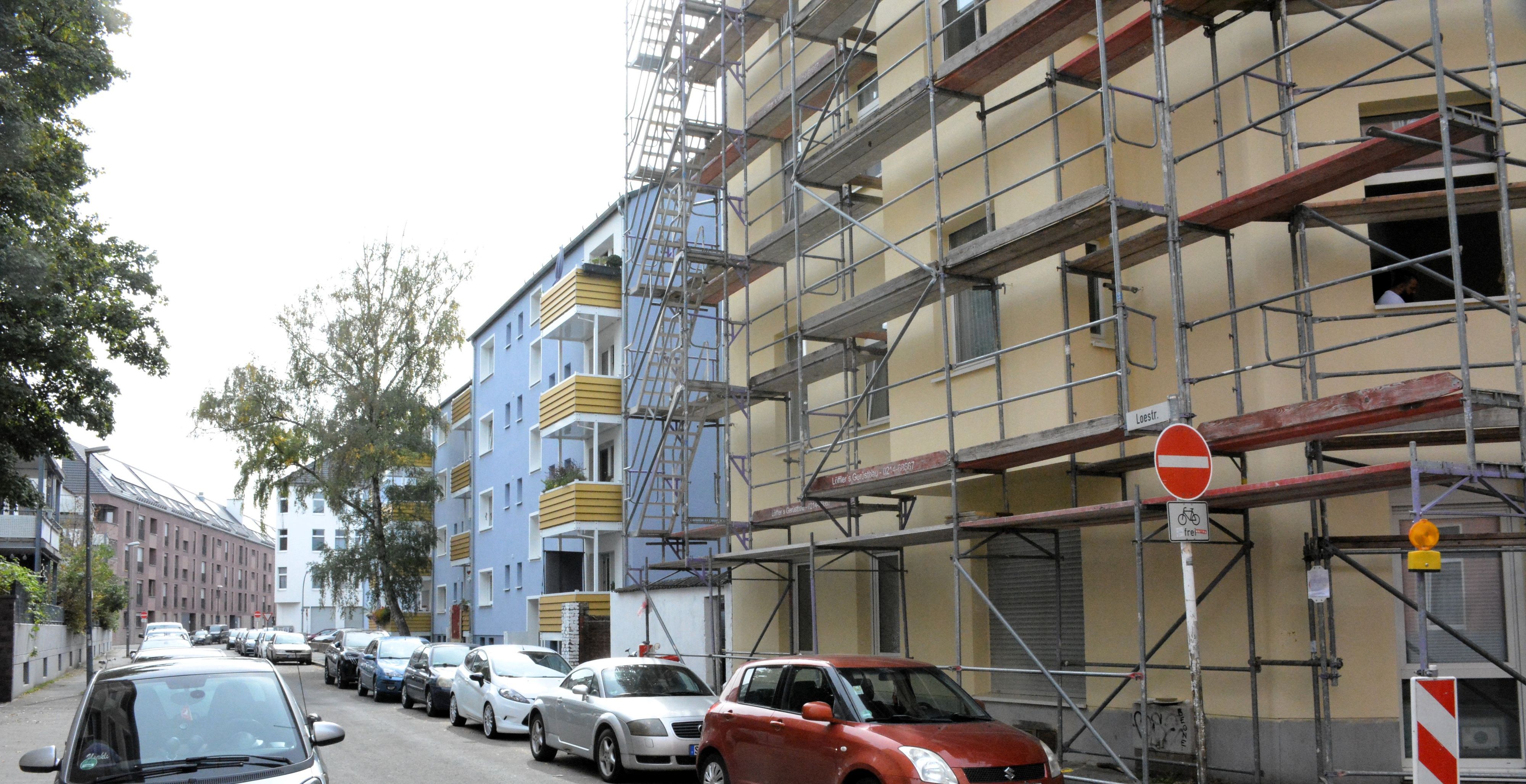 Blick auf ein eingerüstetes Haus. Benachbarte Häuser sind bereits saniert.