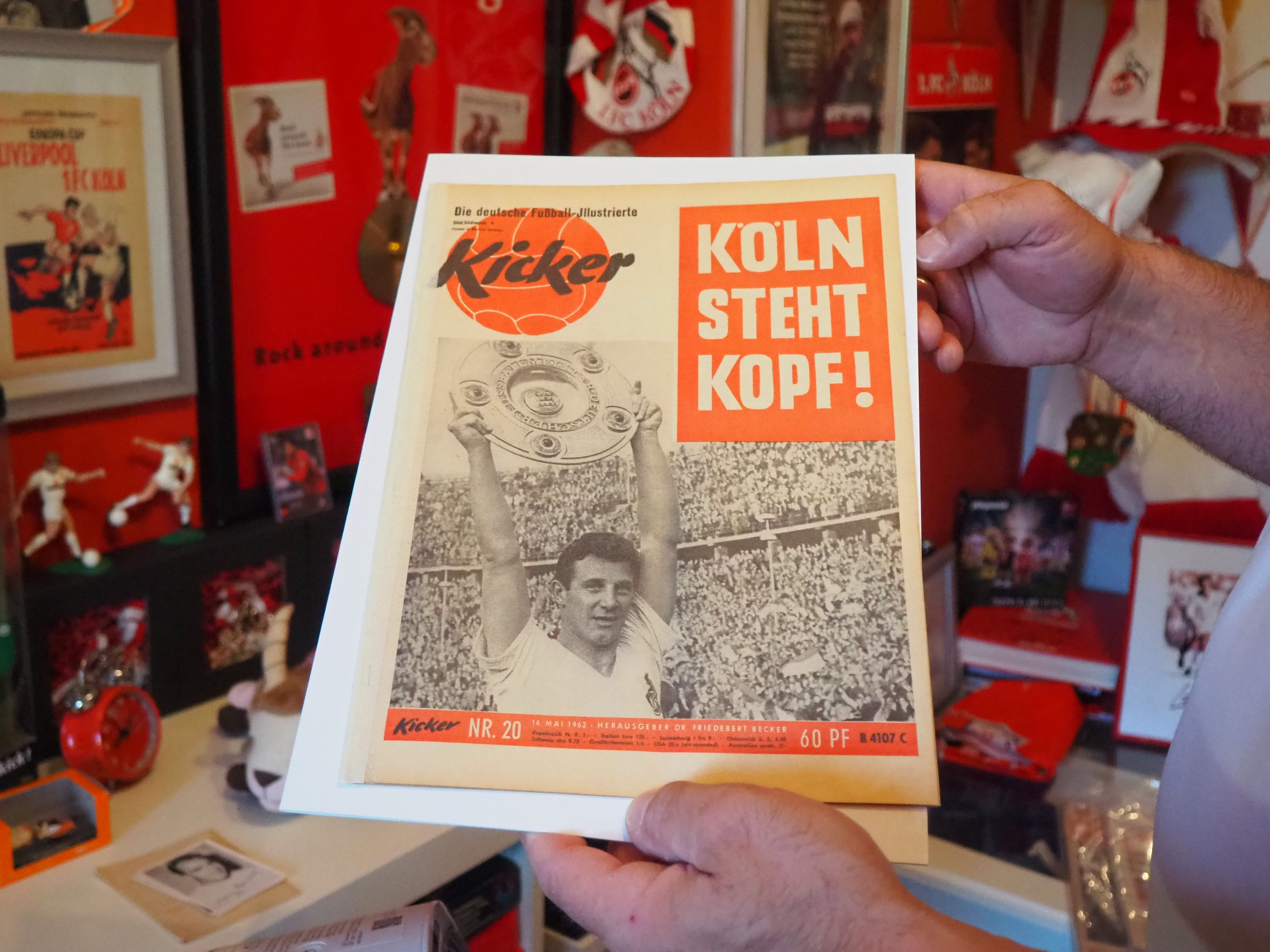 Auf der alten Ausgabe des Magazins „Kicker“ steht "Köln steht kopf". Dazu ist das Bild des Spielers Hans Schäfer zu sehen, der die Meisterschale in die Höhe hält.