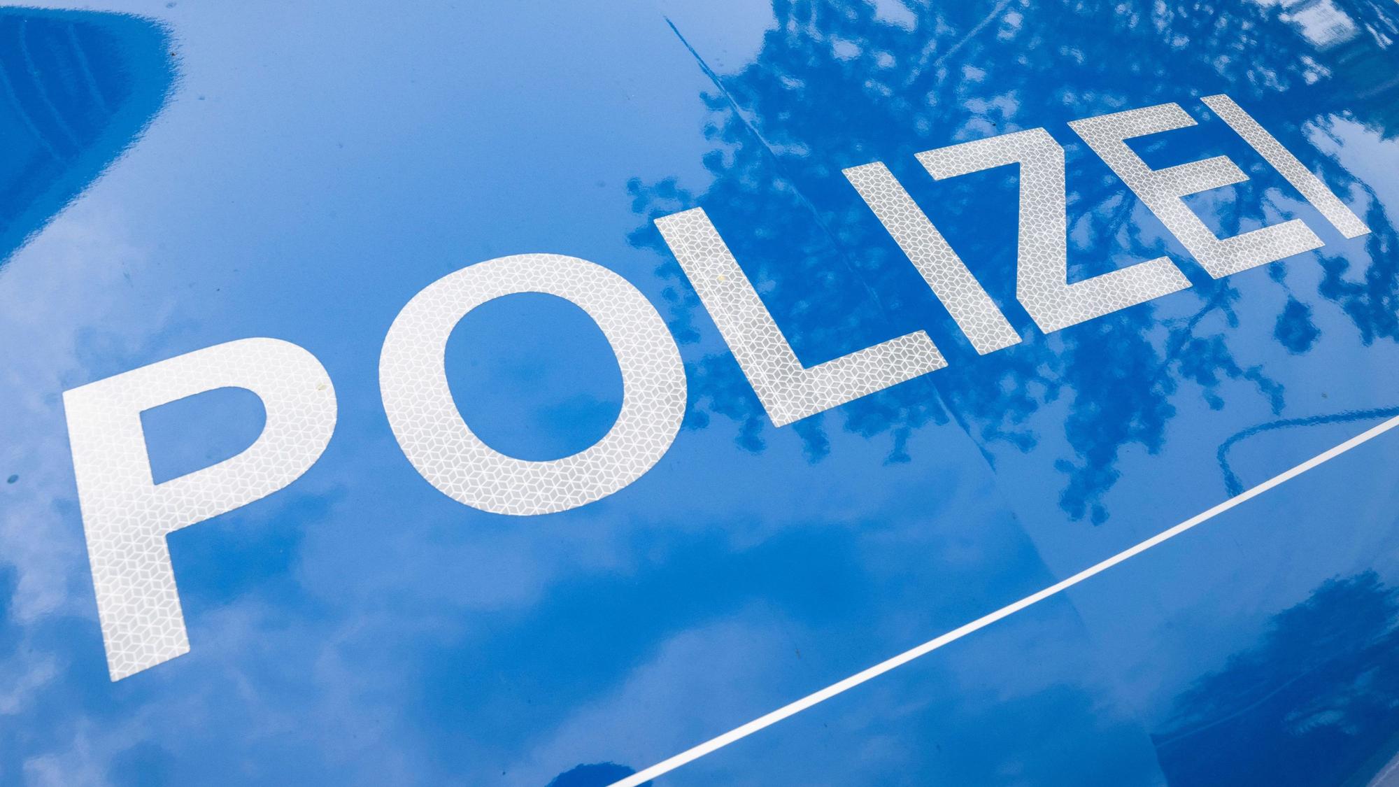 Der Schriftzug „Polizei“ ist auf einem Streifenwagen zu lesen.