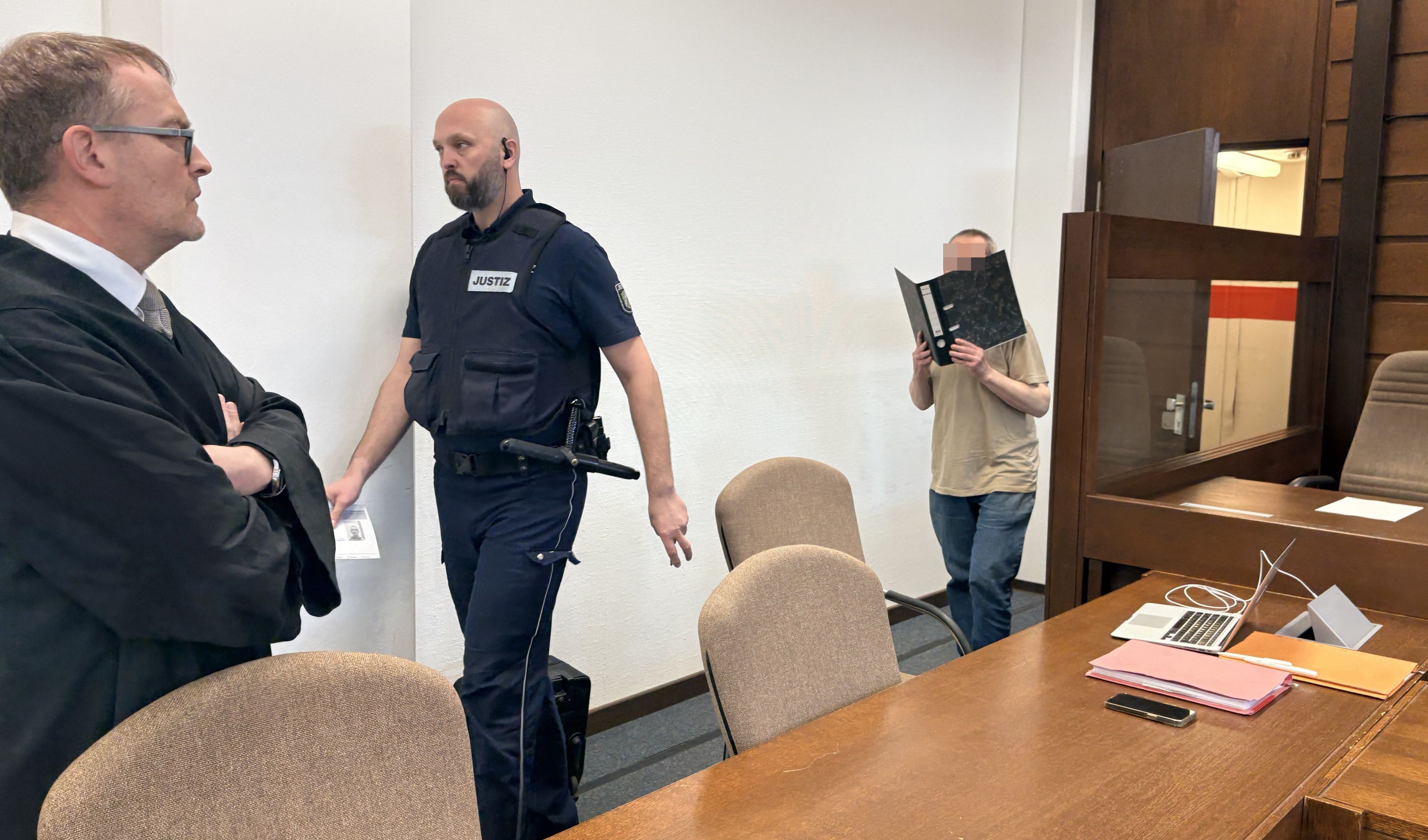 Der Angeklagte Heinz W. (66) wird von einem Wachtmeister zum Prozess im Landericht gebracht. Links: Verteidiger Jan Heeg
