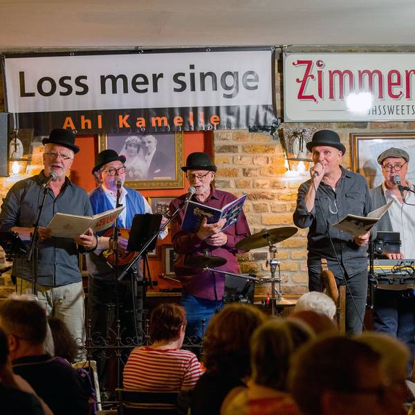 Eine fünfköpfige Band steht auf der Bühne einer Kneipe.