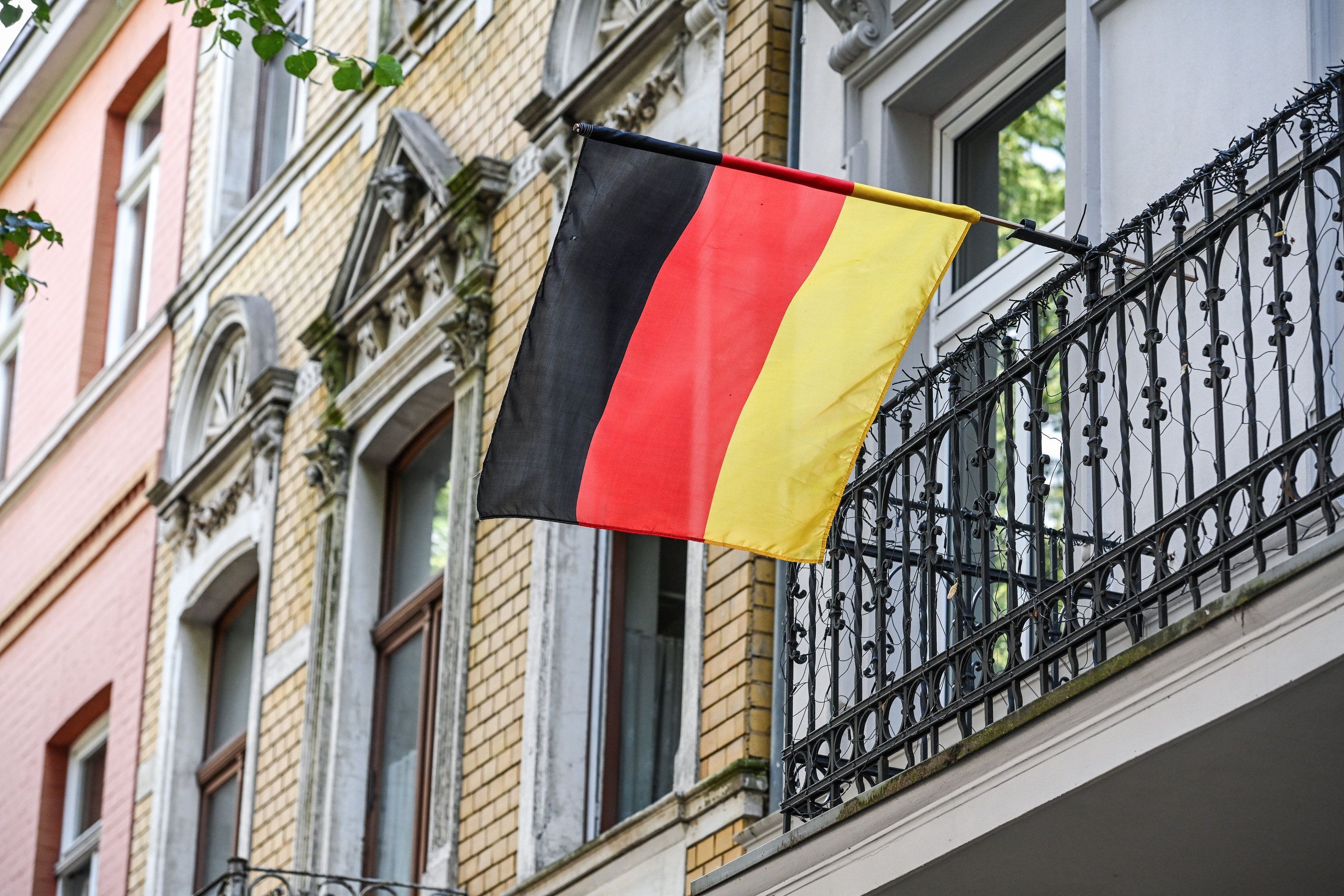 Eine Deutschlandflagge weht am Balkon eines Hauses in Bonn.