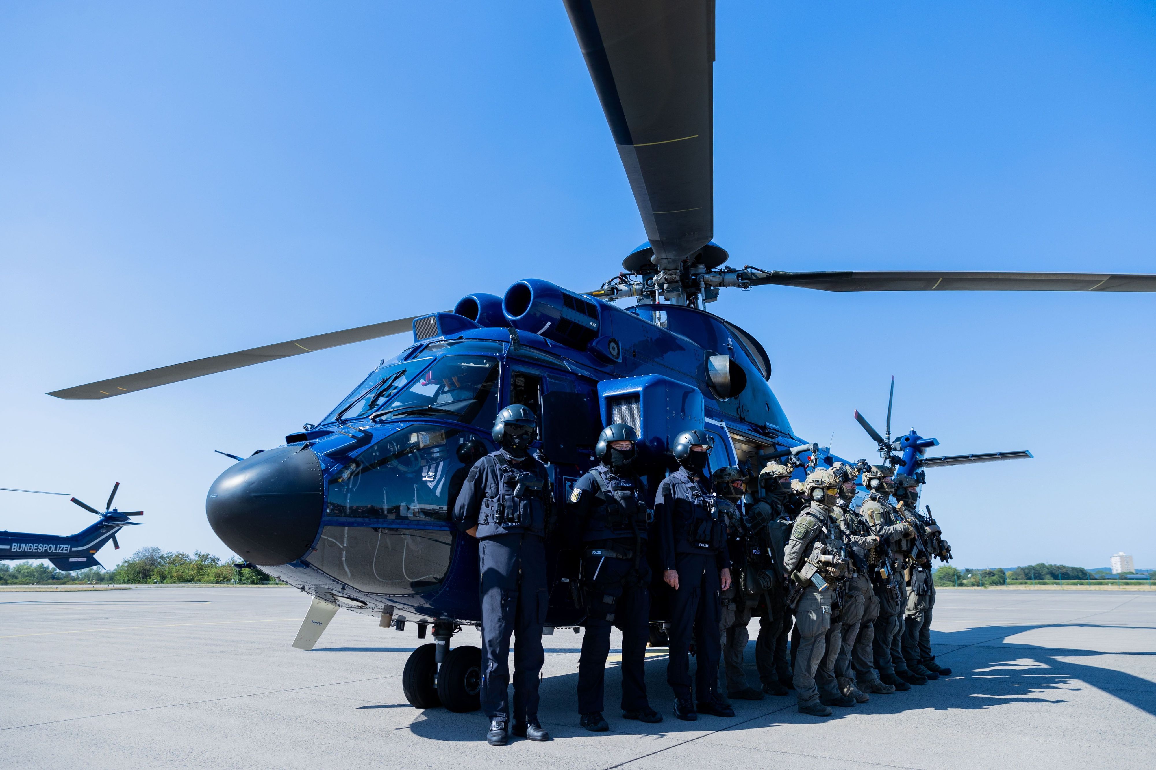 Einsatzkräfte der GSG 9 und der Bundespolizei-Fliegerstaffel stehen zusammen vor einem Hubschrauber „Super Puma“ in Sankt Augustin. (Archivbild)
