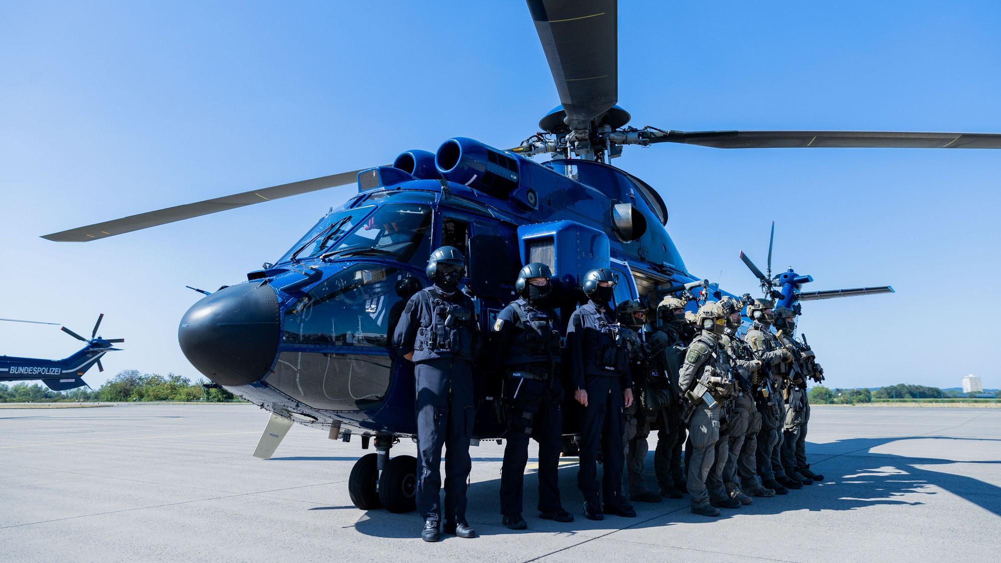 Einsatzkräfte der GSG 9 und der Bundespolizei-Fliegerstaffel stehen zusammen vor einem Hubschrauber „Super Puma“ in Sankt Augustin. (Archivbild)