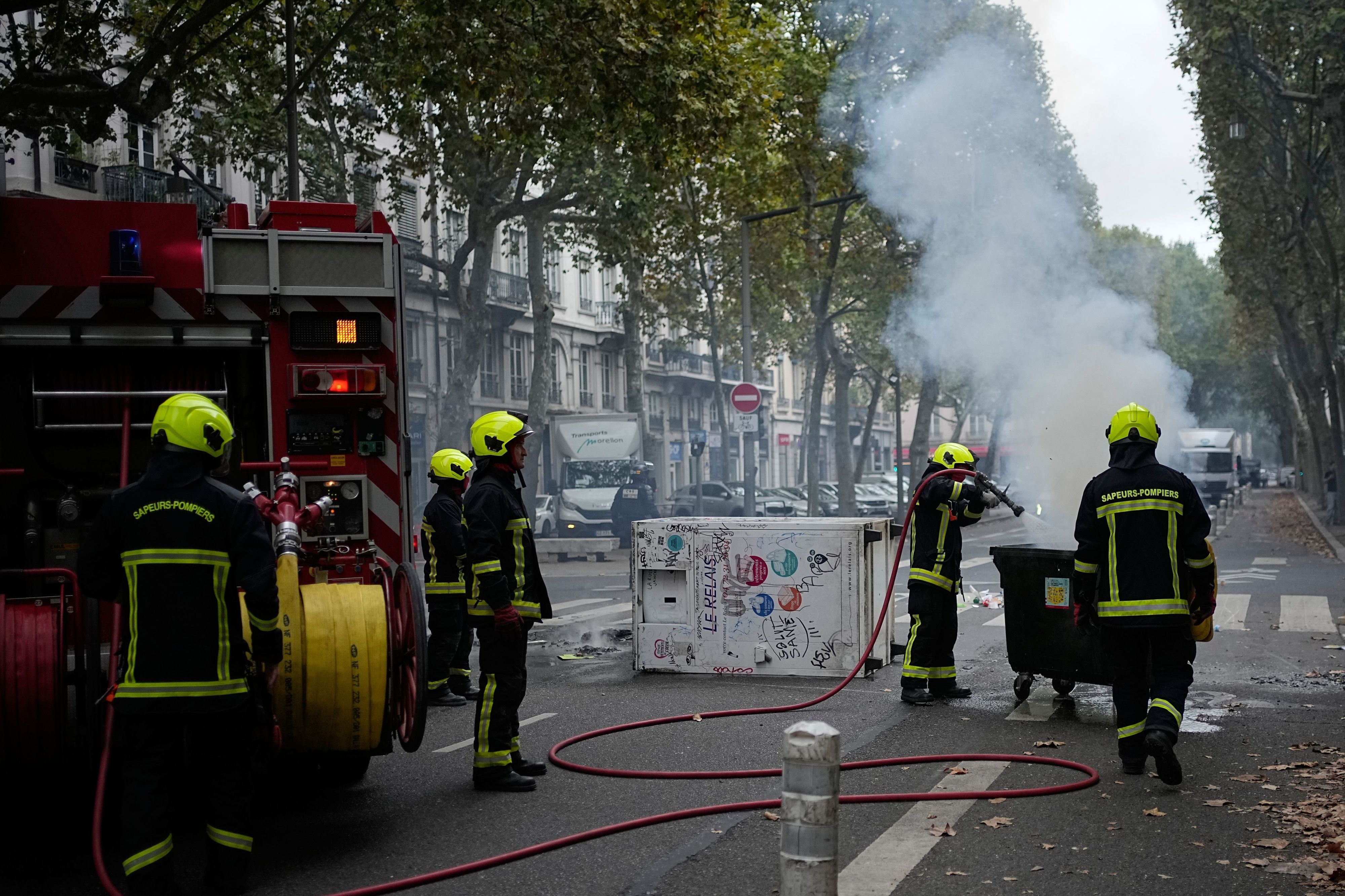 Feuerwehrleute löschen in Lyon einen Brand, während Schüler gegen die Unterfinanzierung von Schulen protestieren.