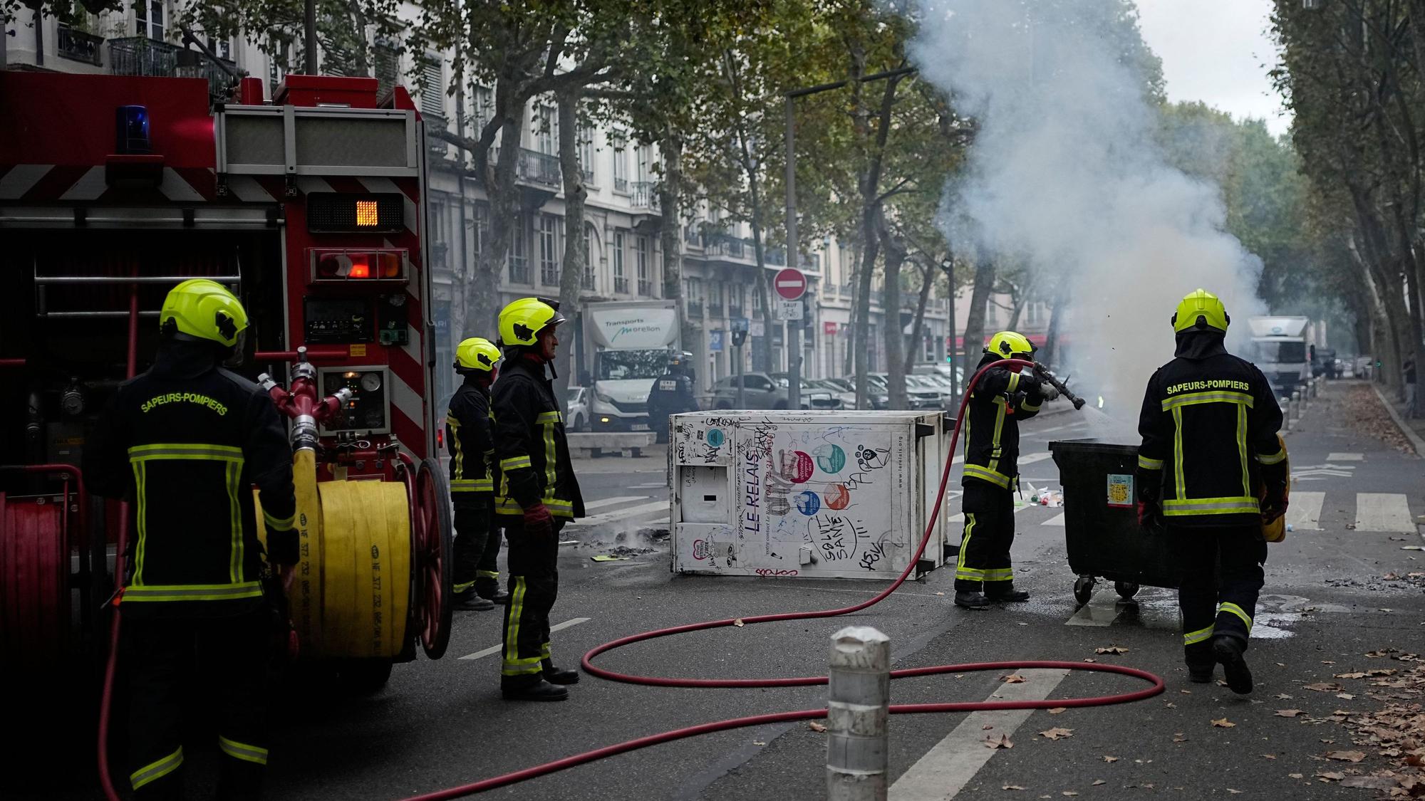 Feuerwehrleute löschen in Lyon einen Brand, während Schüler gegen die Unterfinanzierung von Schulen protestieren.