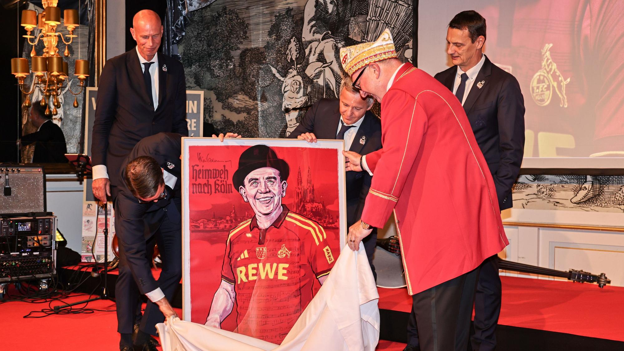 Der FC-Vorstand überreicht ein Bild von Willi Ostermann im Kölner Trikot.