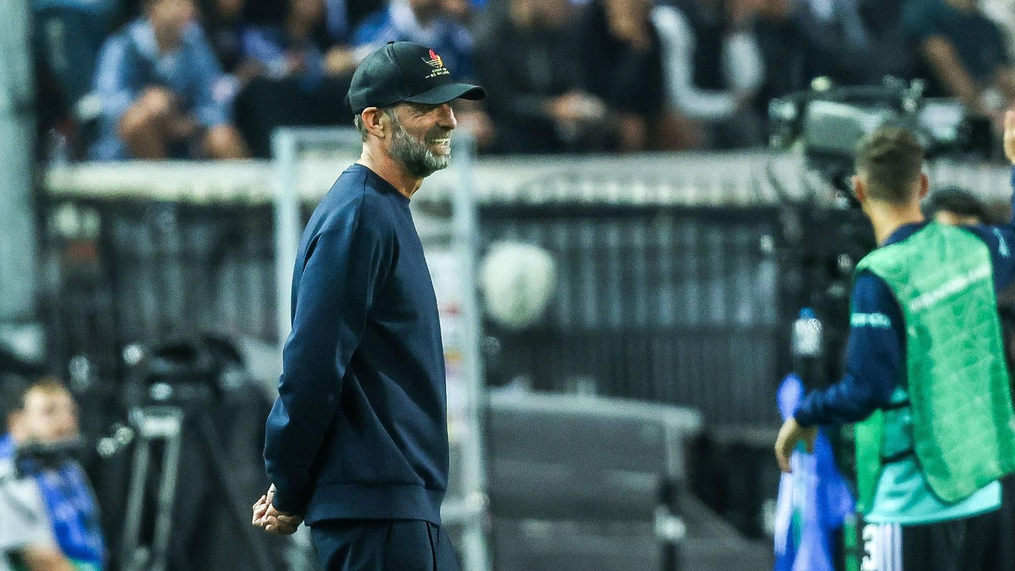Jürgen Klopp steht an der Seitenlinie und hat die Arme hinter dem Rücken verschränkt.
