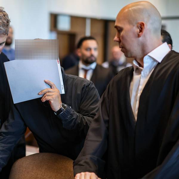 Einer der sieben Angeklagten mit den Verteidigern Marc Donay (l.) und Jonas Bau beim Prozessauftakt im Kölner Landgericht.
