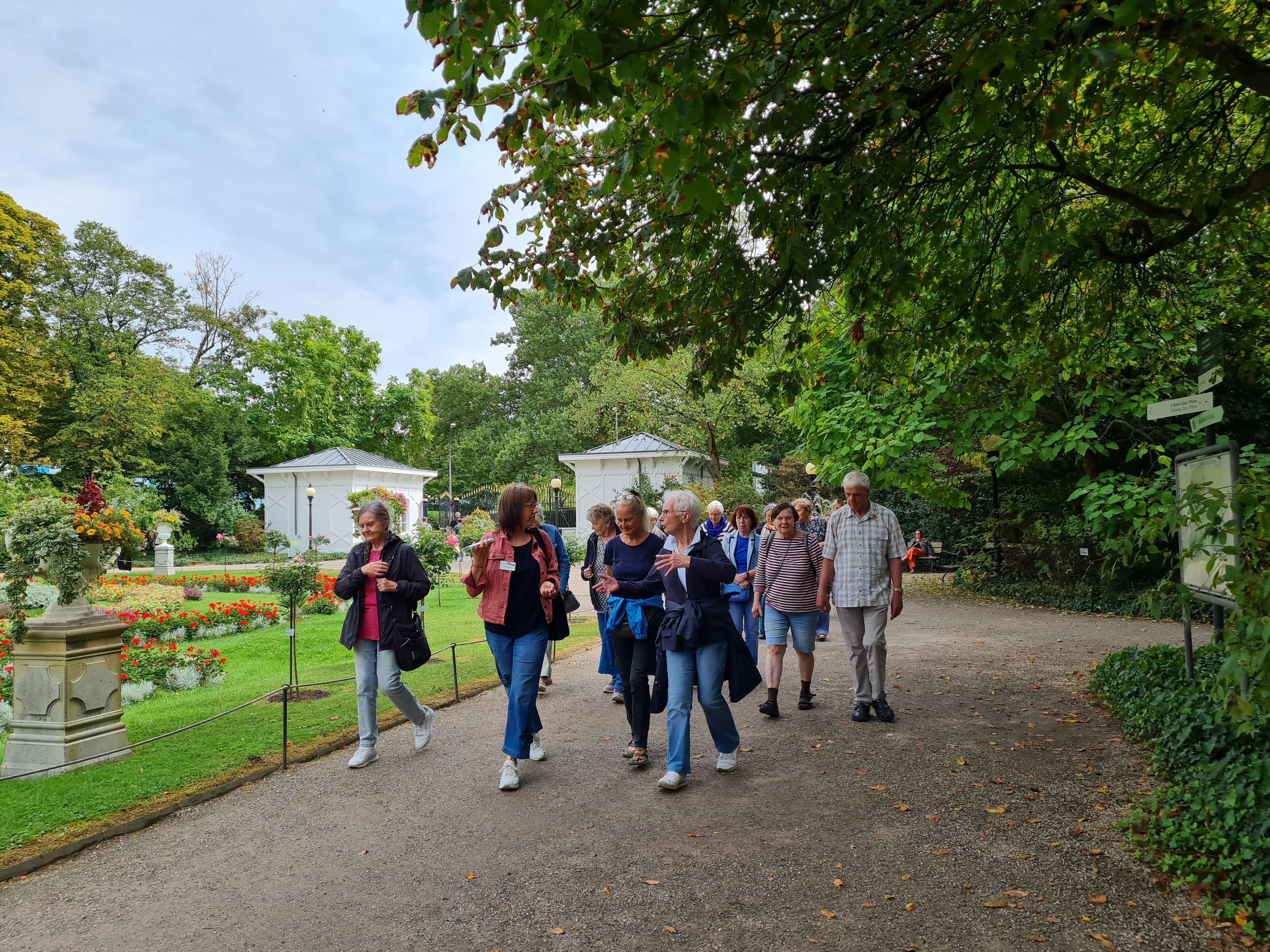 Eine Gruppe von Frauen und Männern geht durch einen Park.